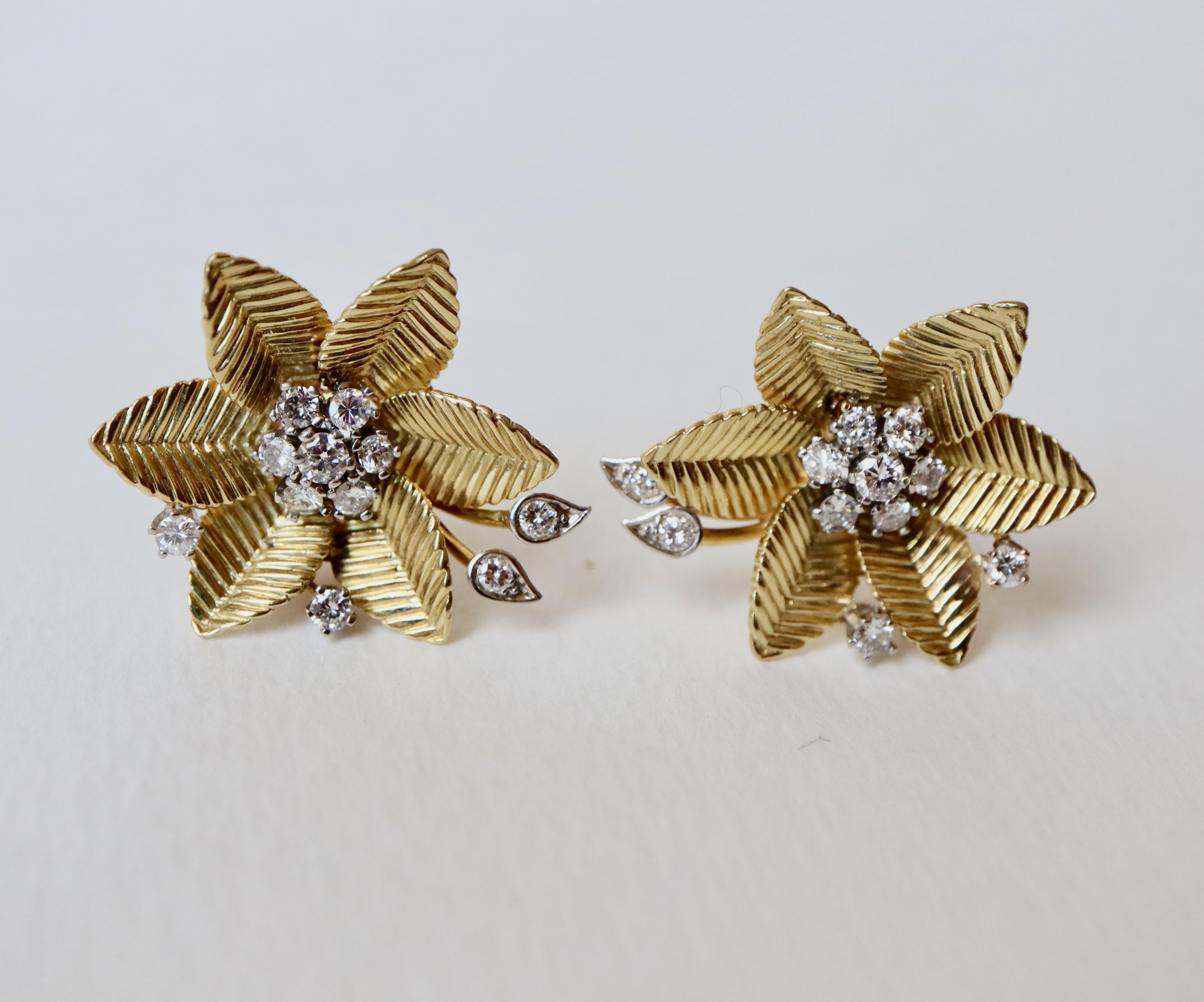 1950s clip-on earrings with a flower motif in 18 kt yellow gold. The flowers are composed of six gadrooned petals and the pistil is formed of 7 diamonds set in white gold and 4 stems finished with diamonds set in 18 Kt white gold. That is 11