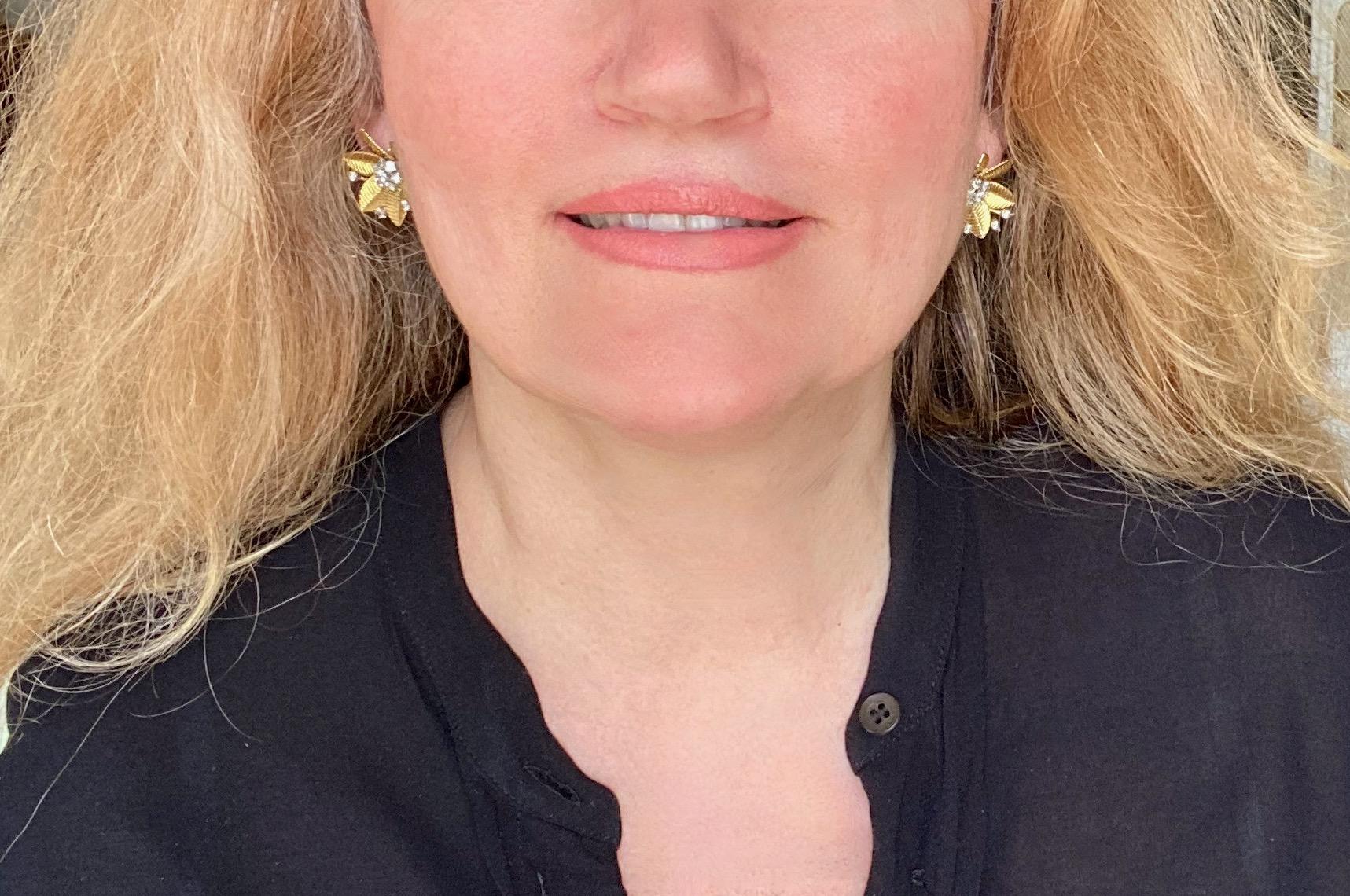 Boucles d'oreilles à clip des années 1950 avec un motif floral en or jaune 18 carats. Les fleurs sont composées de six pétales godronnés et le pistil est formé de 7 diamants sertis en or blanc et de 4 tiges terminées par des diamants sertis en or