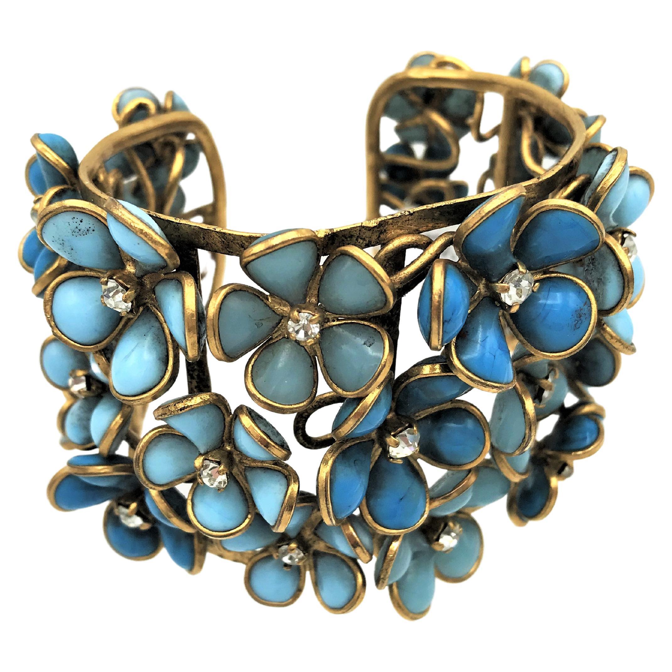 Beautiful cuff consisting of many individual blue glass flowers in the style of Chanel. 
this beautiful cuff ist unsigned  and probable made by Gripoix employees.
It is a great look with wearing with Jeans and white blouse. 

Measurement: Height 5.5