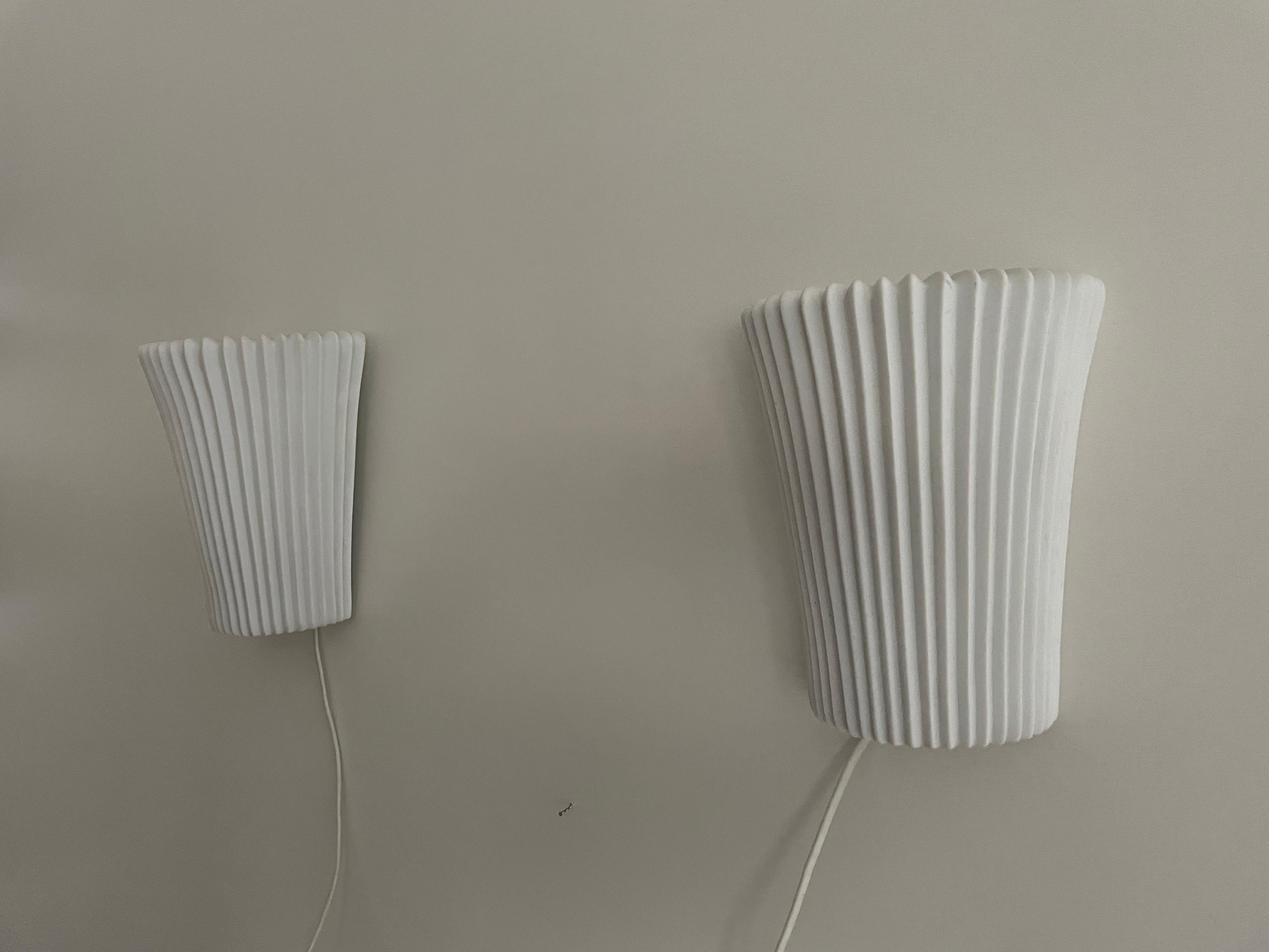 Paar Wandleuchter aus weißer Keramik mit Blumenmuster, 1960er Jahre, Deutschland

Sehr schöne Wandlampen von hoher Qualität.

Die Lampen sind in sehr gutem Vintage-Zustand.

Diese Lampen funktionieren mit E27 Standard-Glühbirnen. 
Verkabelt und für