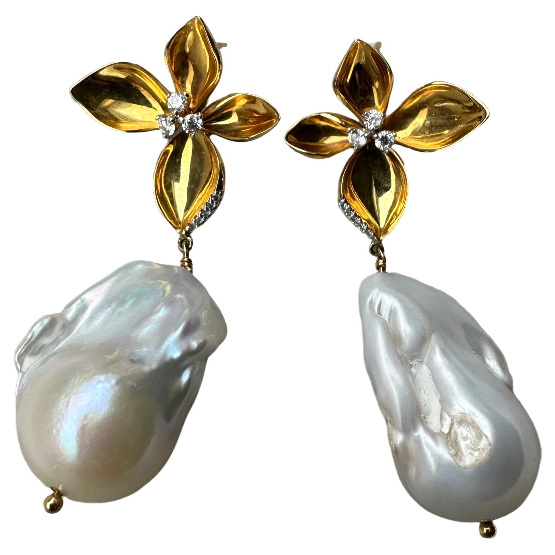 Crown Jewel of the Renaissance Collection.

Meticulously handcrafted floral design exudes a refined yet playful look.

Lustrous gold petals surround the diamond for that extra shimmer.

Finished with dangling Baroque pearl to make it the show