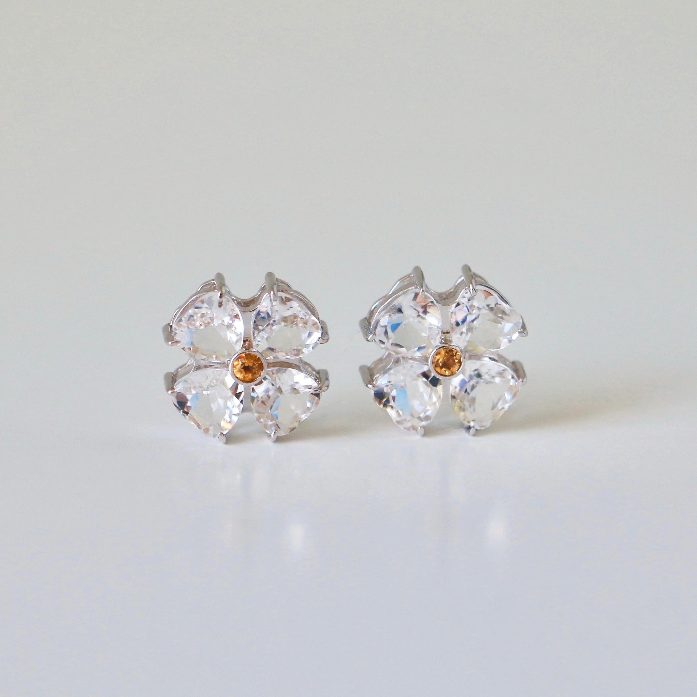 Oro bianco massiccio 18 carati

Gemme di Citrino naturali: Taglio rotondo, dimensioni 2,5 mm ciascuna

Gemme di quarzo naturale trasparente: Forma di cuore, dimensioni 6x6 mm ciascuna

Orecchini: A forma di fiore 

Peso lordo: 6,8 g

Le gemme