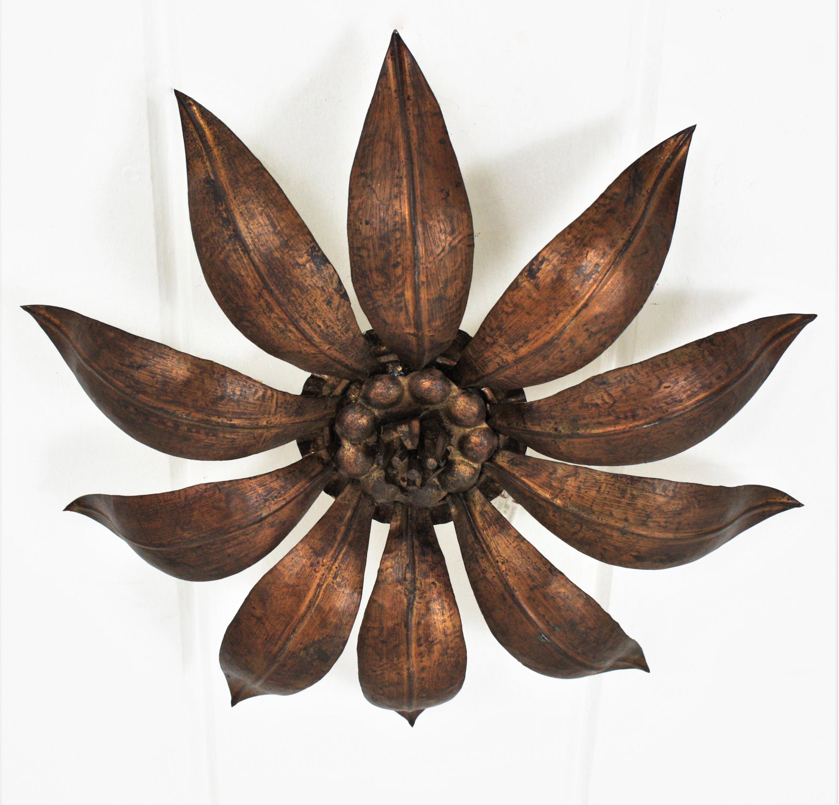 Eye-catching gold leaf bronze-gilt metal flower shaped flush mount, France, 1940s.
This handcrafted iron ceiling light has a gilding finishing in bronze golden tone and a nice aged patina.
It can be placed flush mounted or as a pendant hanging from