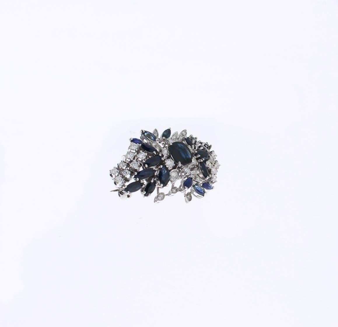 Broche en forme de fleur avec 19 saphirs taillés en ovale et en navette pesant environ 5,7 ct. et 38 diamants taillés en brillant pesant au total environ 1,0 ct. Monté en or blanc 18 carats. Mesures : 1.56 x 0.98 in ( 4 x 2,5 cm )