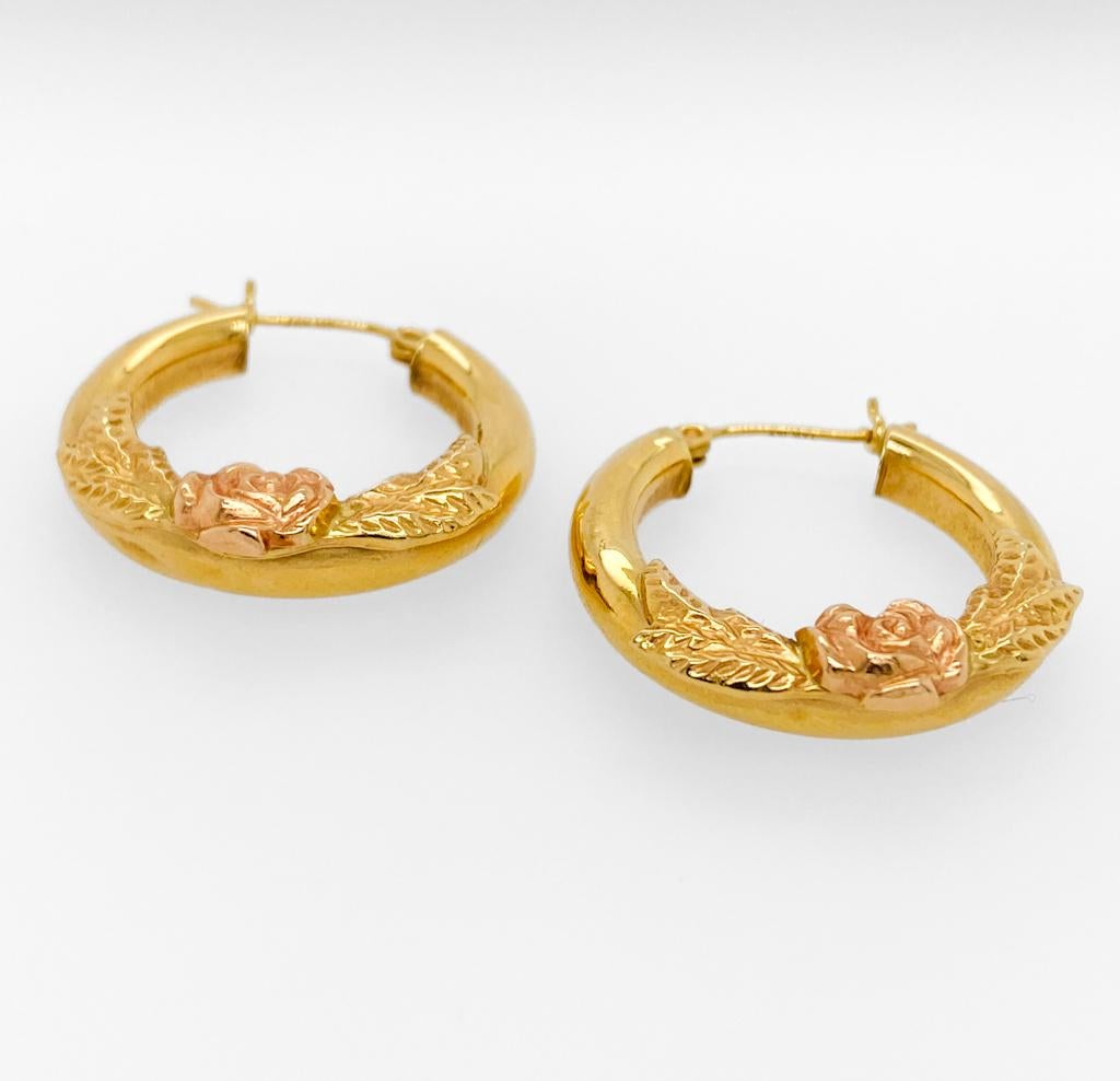 Diese farbenprächtigen Ohrringe aus 14-karätigem Gelbgold sind dank ihrer Hohlrohrkonstruktion vielseitig einsetzbar und tragbar. Jeder Creolenring ist mit einem Blumenmuster verziert. Am unteren Ende jedes Reifs sitzt eine schöne Rose, die in den