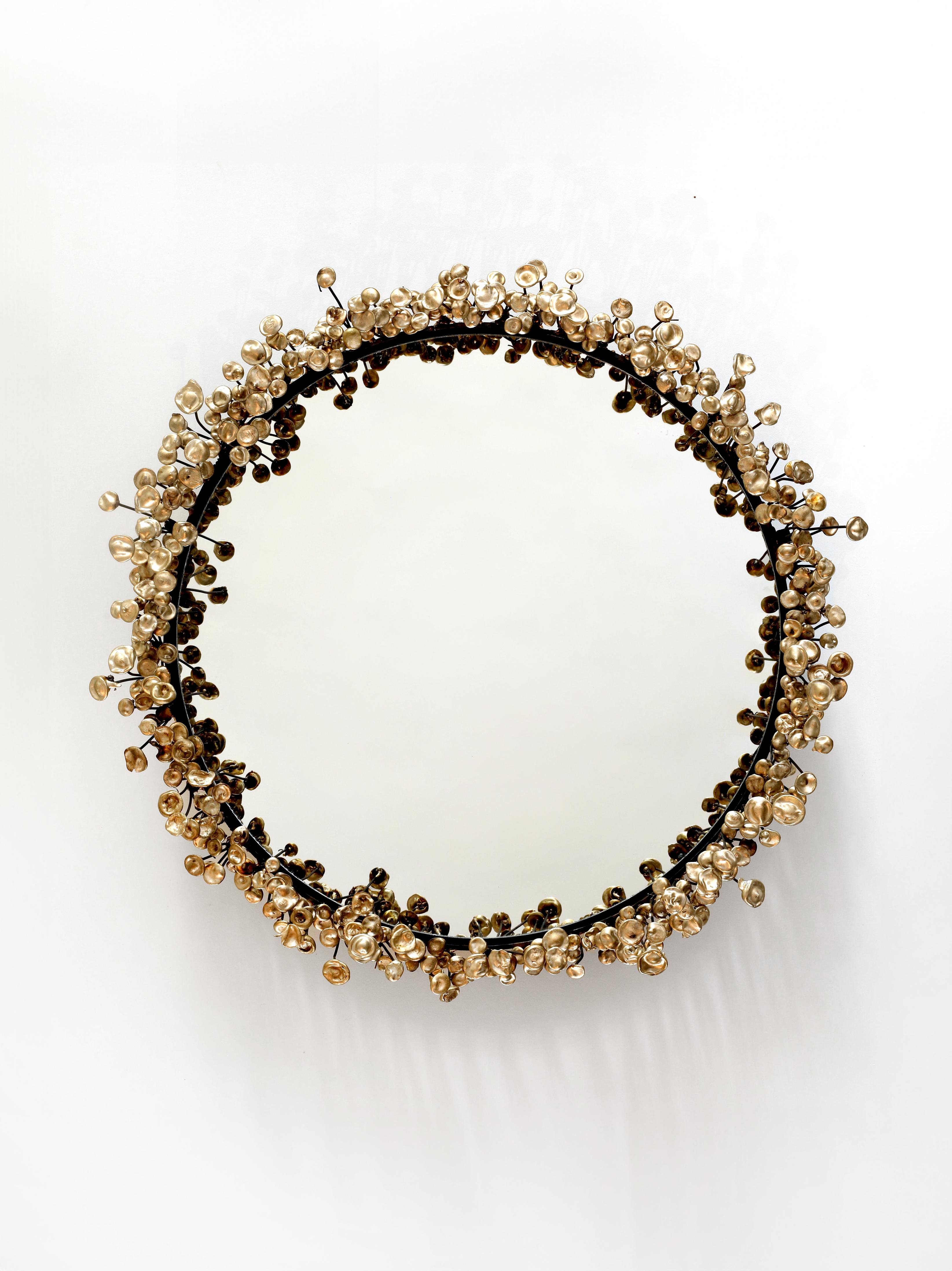 The Flower Mirror is made up of hundreds of unique bronze blossoms welded to a steel frame. Each piece is one of a kind and therefore may differ slightly from the images.