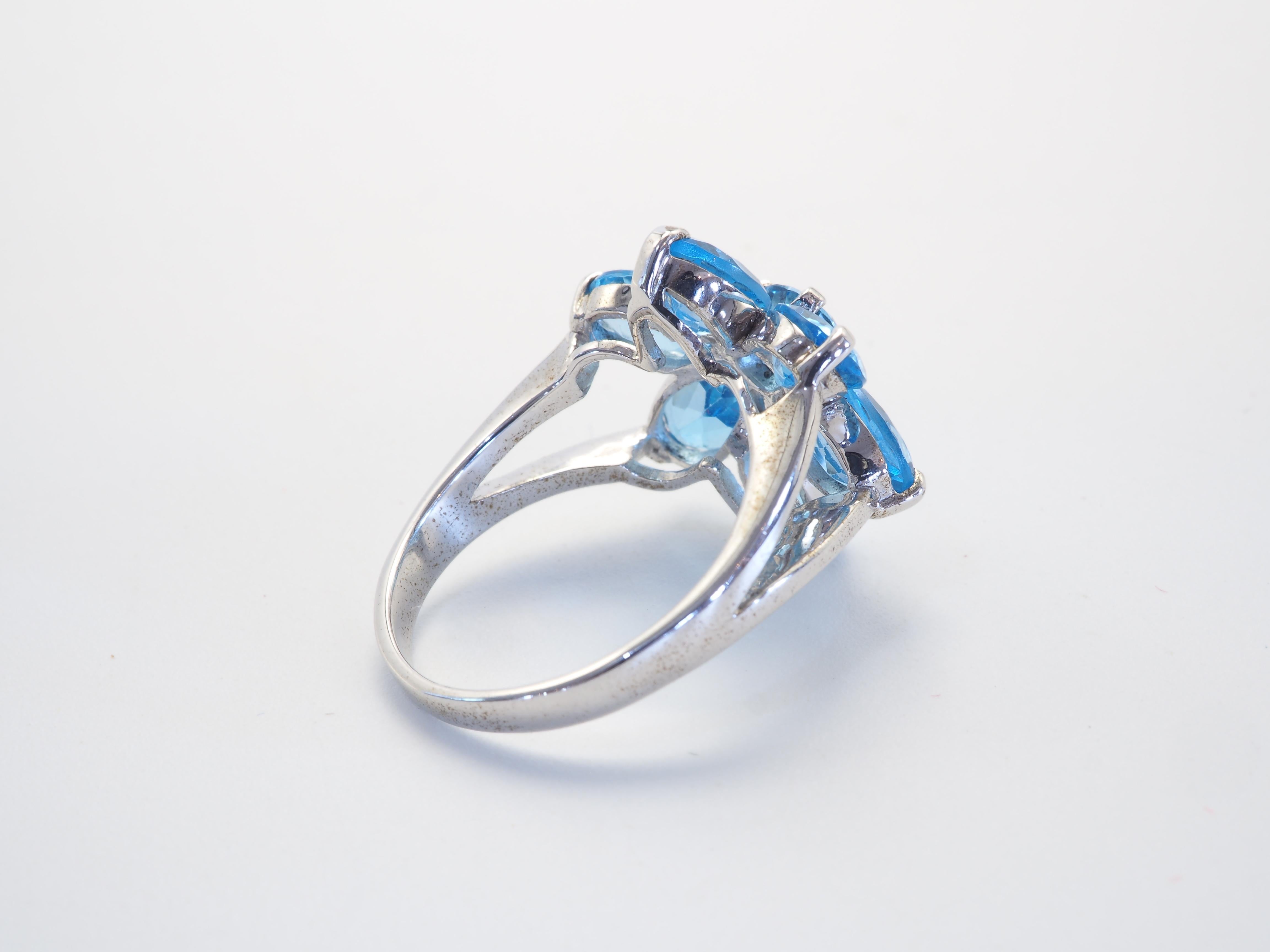 Stunning flower motif ring with clear and saturated blue topaz stones. The prong work at middle bud is a work of art. The design is made to be fashionable, and it can be a fun ring for everyday wear. We can resize for you for additional