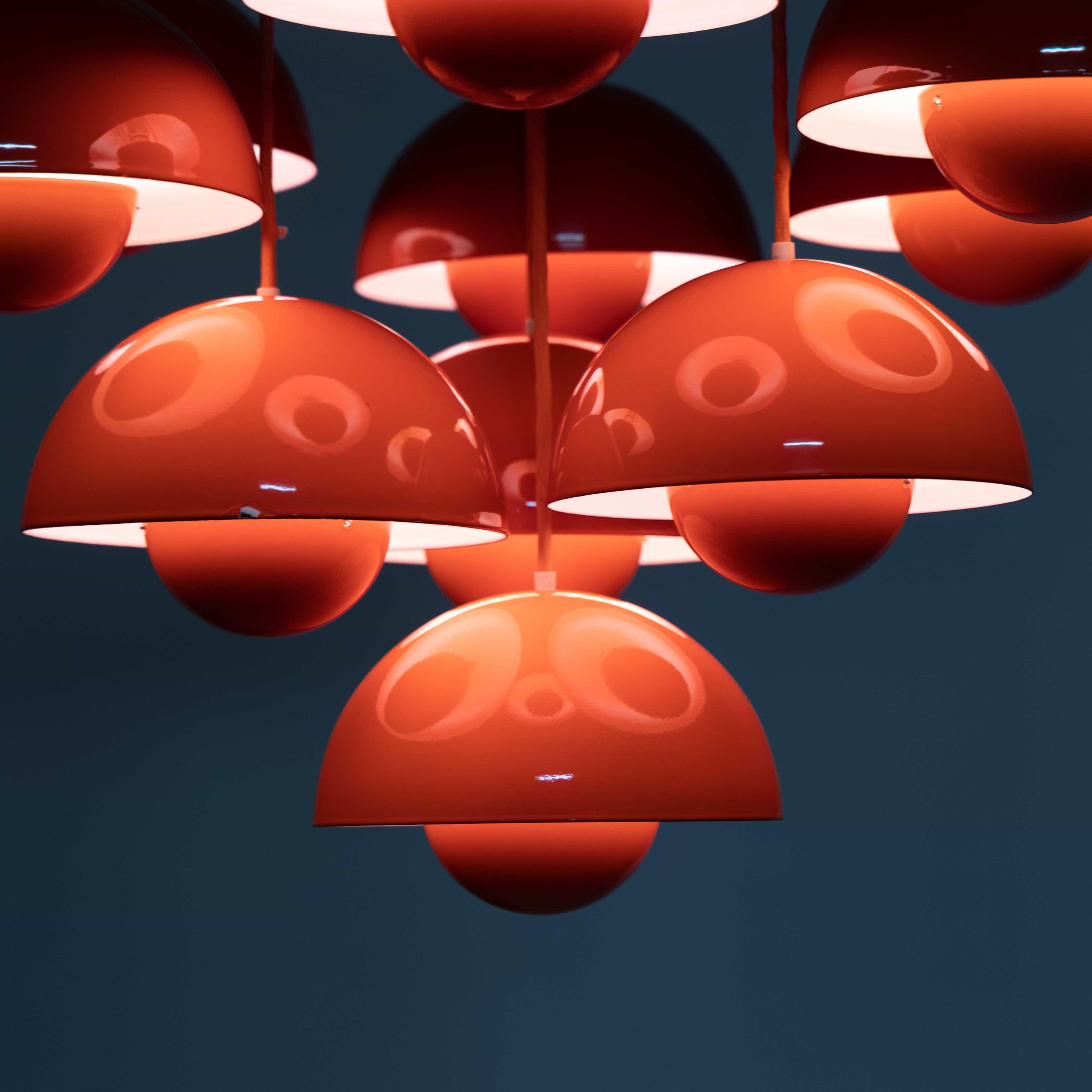 Red chandelier consisting of ten Flower Pot pendant lights designed by Verner Panton for Louis Poulsen in 1968. The Flower Pot lights are mounted in different lengths on a red, square perforated plate. This combination was produced in 1971/72 for
