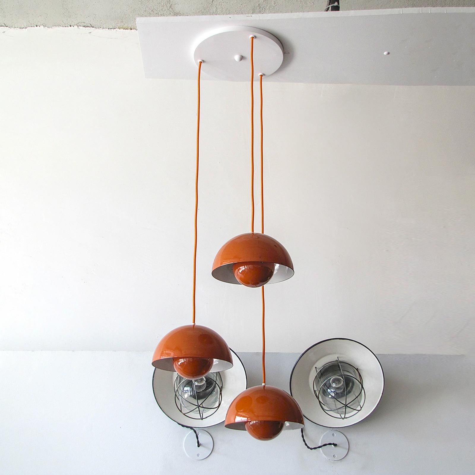 Wonderful 1970s flower pot hanging lights by Verner Panton for Louis Poulsen, three orange enameled pieces with matching new colored cords on a single canopy, insides of the reflector spheres is orange, heights are fully adjustable, one E26 sockets