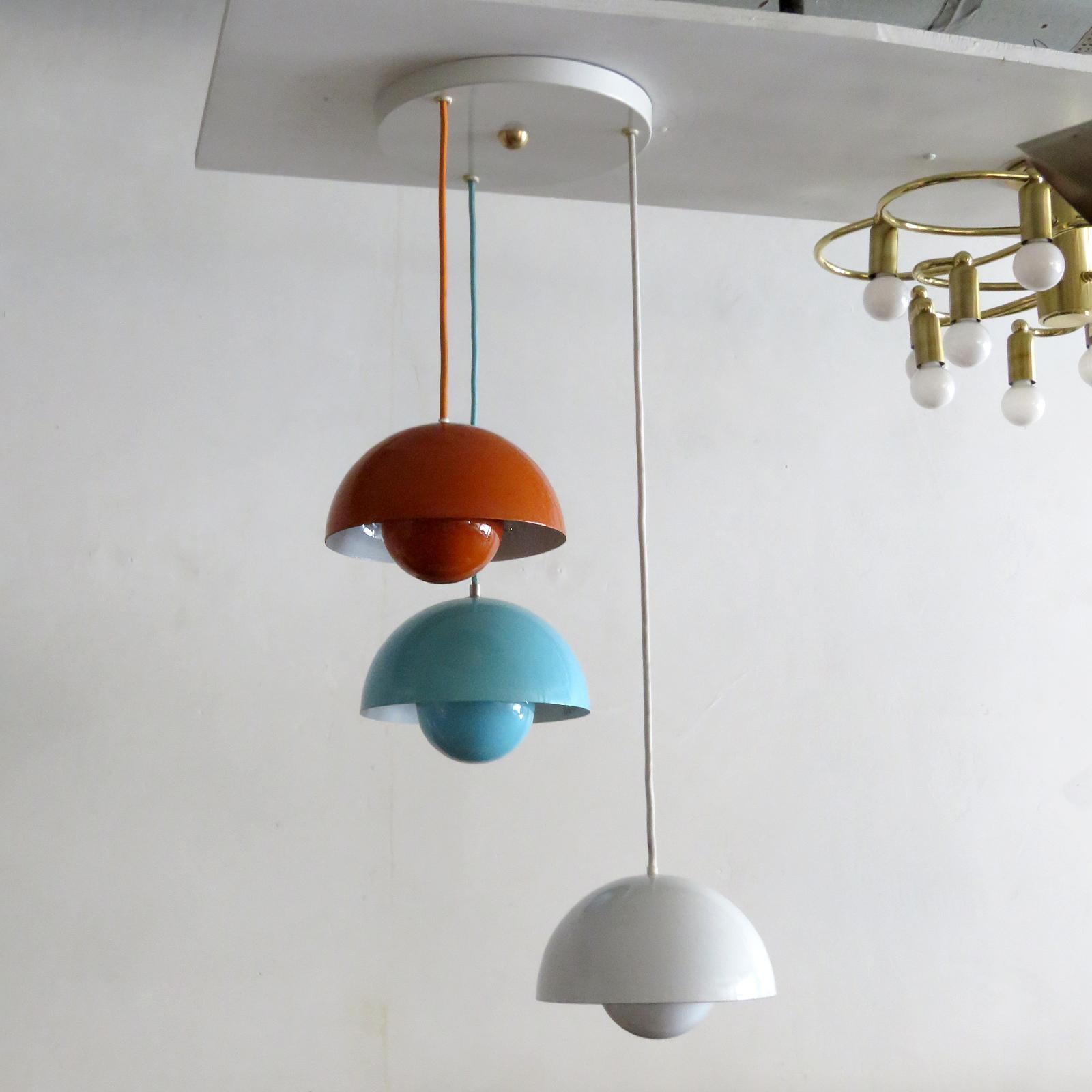 Wonderful 1970s flower pot hanging lights by Verner Panton for Louis Poulsen, three orange, white & blue enameled pieces with matching colored cords on a single canopy, heights are fully adjustable, one E26 sockets per pendant, max. wattage 75w each