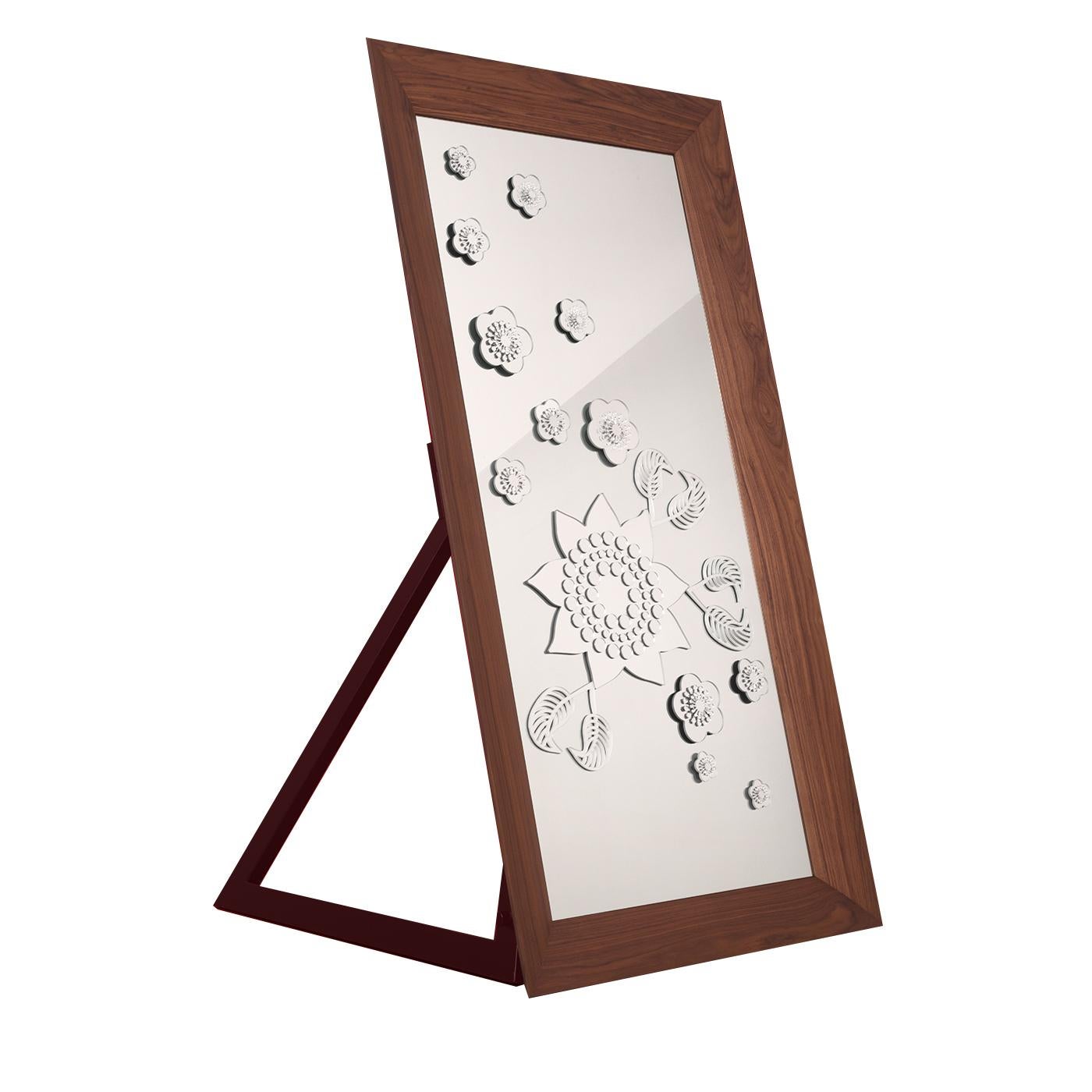 The dramatic simplicity of this mirror comes from the bold, laser-cut, plexiglass flowers and leaves that accent its surface, adding reflections of light and visual appeal. The rectangular frame is made of Canaletto walnut wood frame and can be