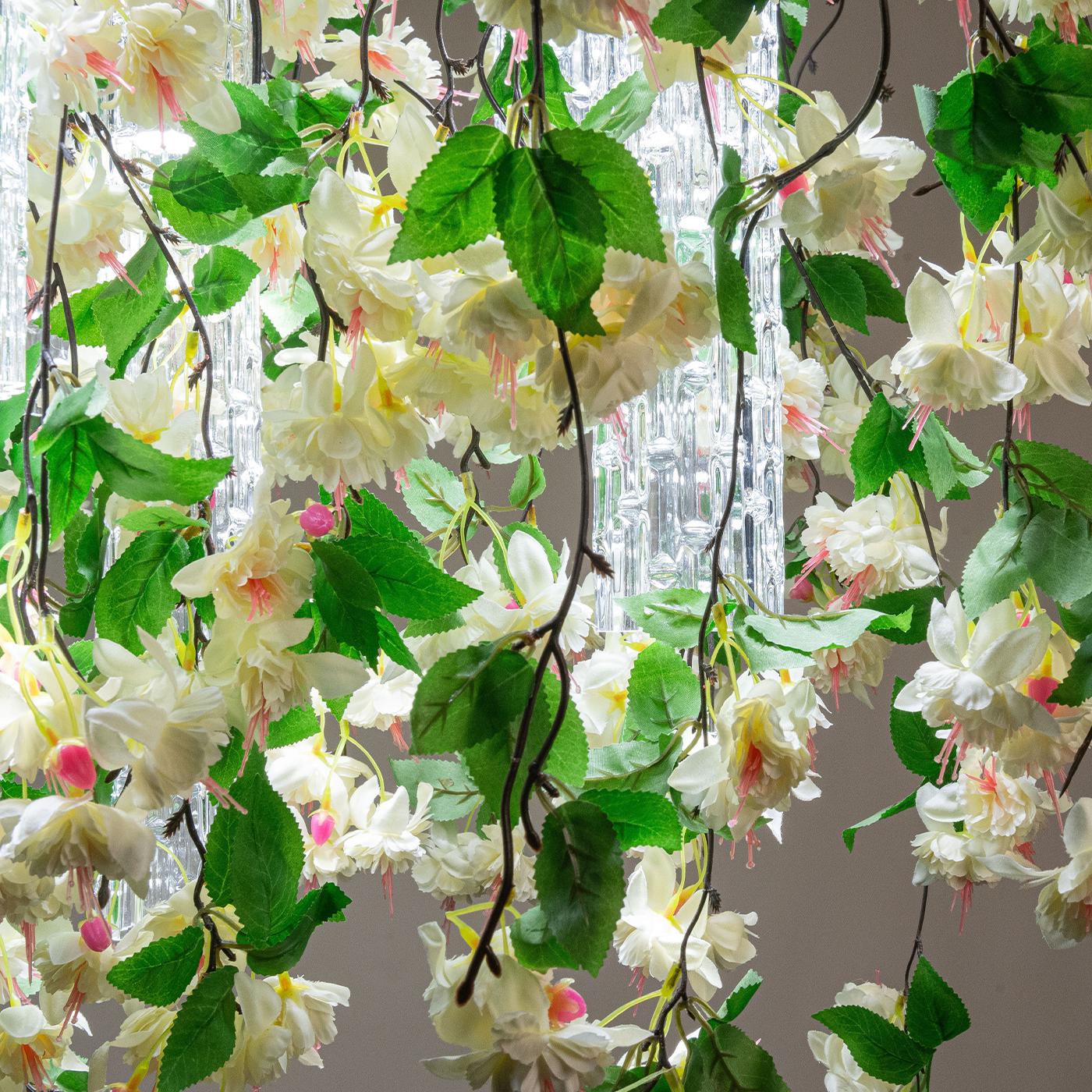 Cette magnifique pièce de design est un pont harmonieux entre la Nature et l'intervention humaine, définie par une glorieuse cascade de fleurs blanches synthétiques dissimulant en partie six abat-jour en verre de Murano faits à la main, chacun