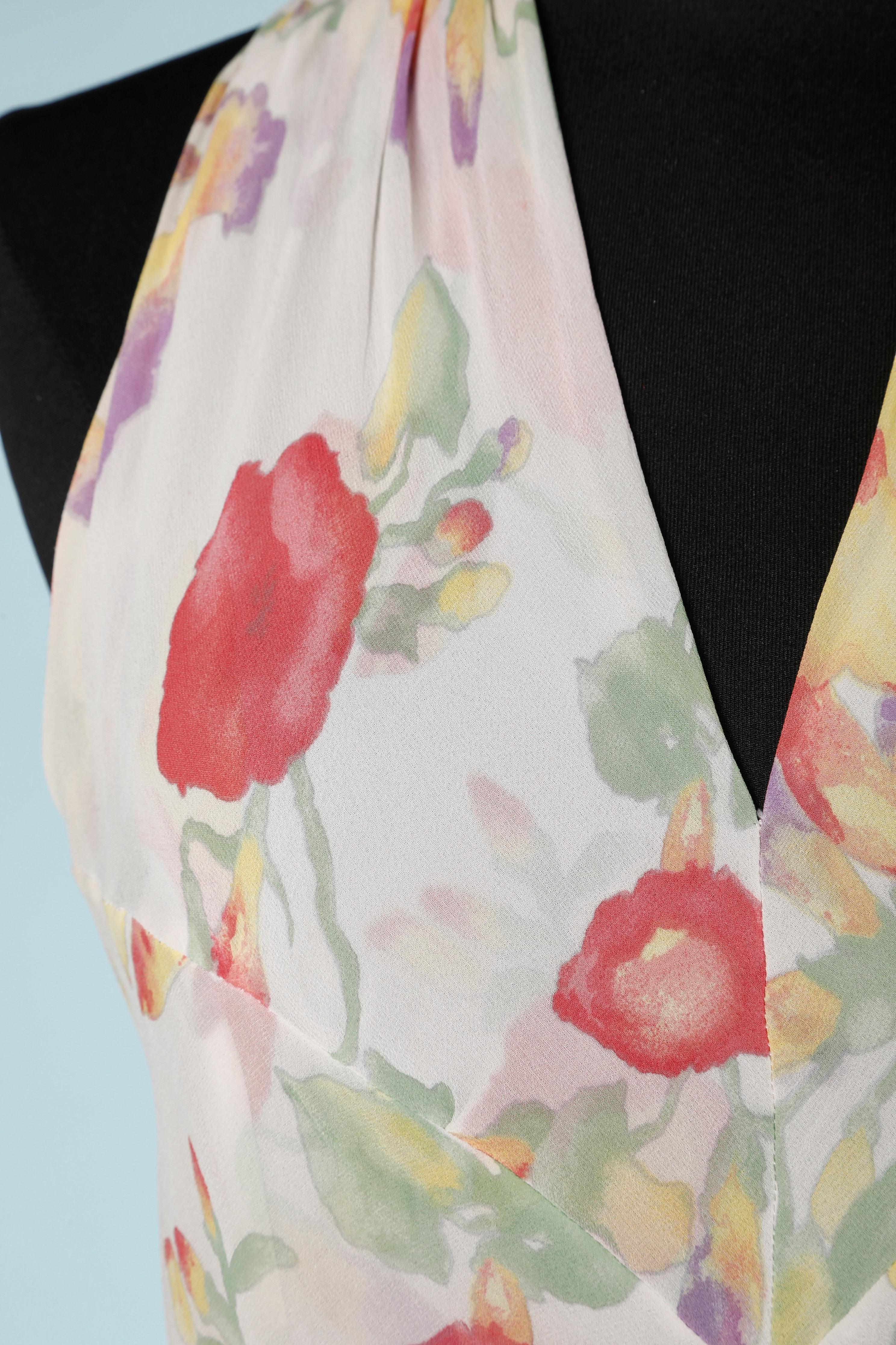 Vestido de gasa con estampado de flores drapeado en las caderas. Efecto envuelto en la parte de la falda. 
Con cremallera en el centro de la espalda . Botones de metal dorado con la marca en la parte central de la espalda y detrás del cuello.
