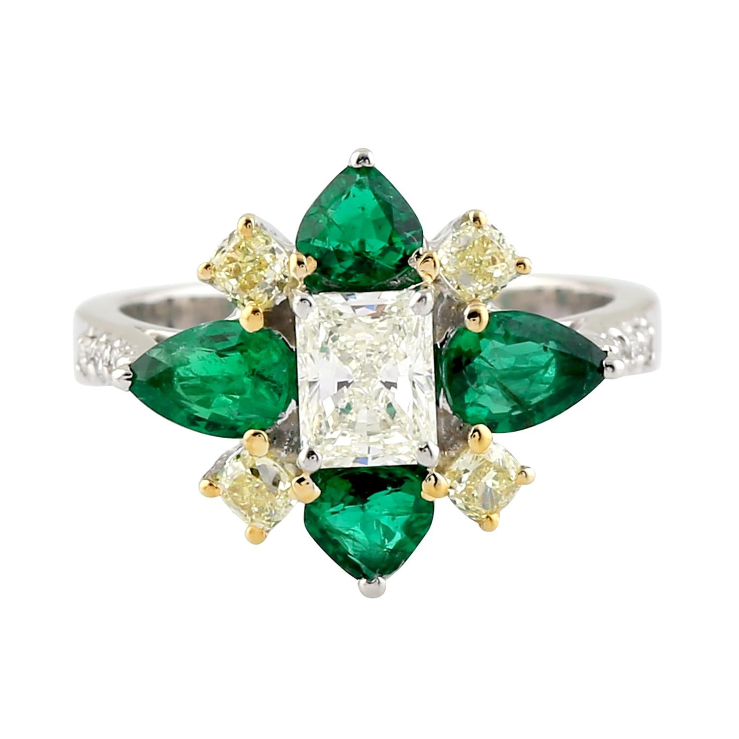 Step into the world of luxury and sophistication with this stunning flower-shaped ring made of 18k gold, featuring dazzling pear-shaped emeralds surrounded by glittering diamonds. The unique design of the ring resembles a blooming flower, with the