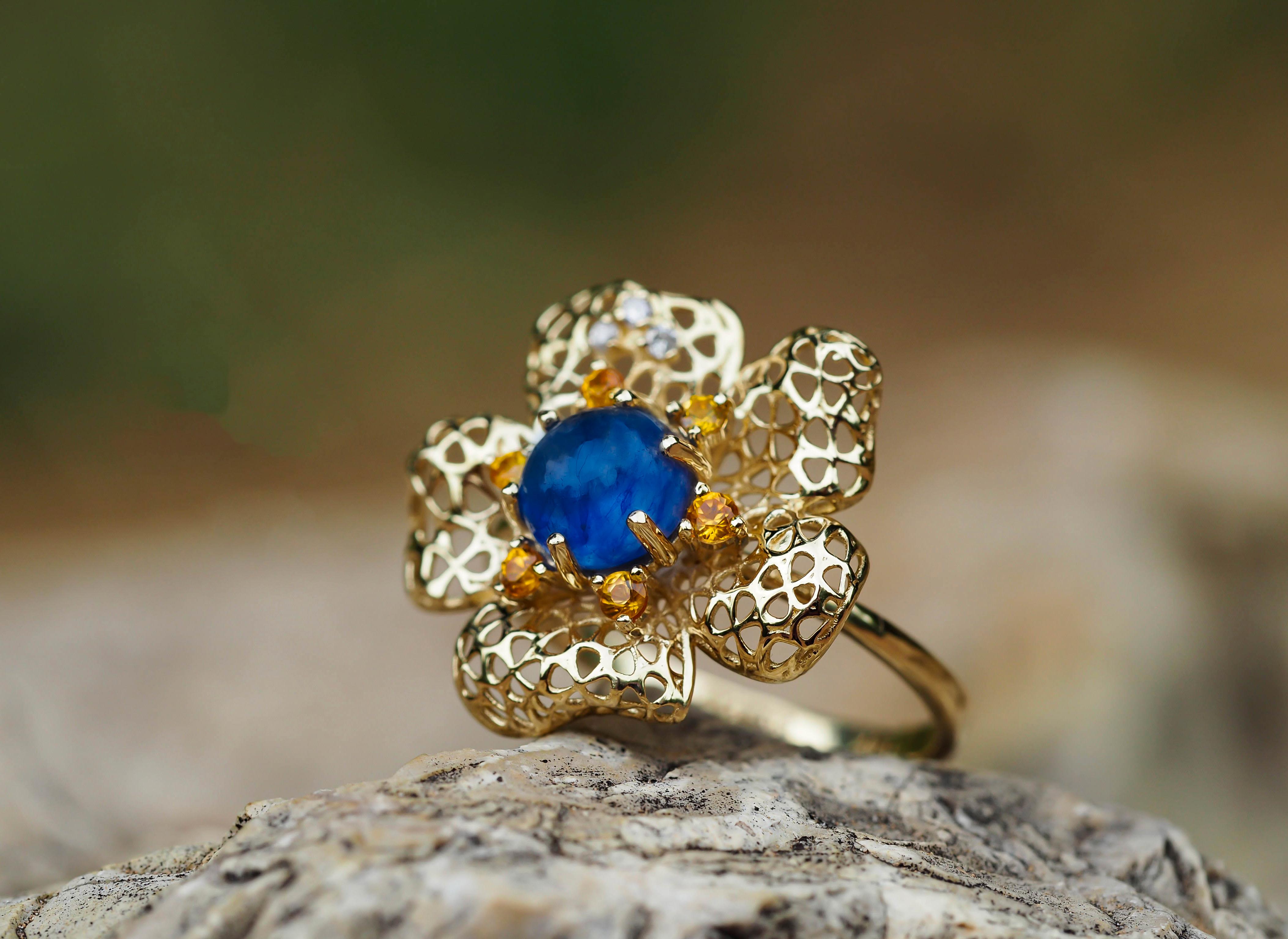 Flower ring with sapphire im 14k Gold. 
Cabochon Sapphire ring. September Birthstone ring. Blue sapphire ring. Gold flower ring.

Weight: 2.51 g. depends from size.
Metal: 14k gold.

Central stone: Sapphire
Cut: Round cabochon
Weight: approx 1.30