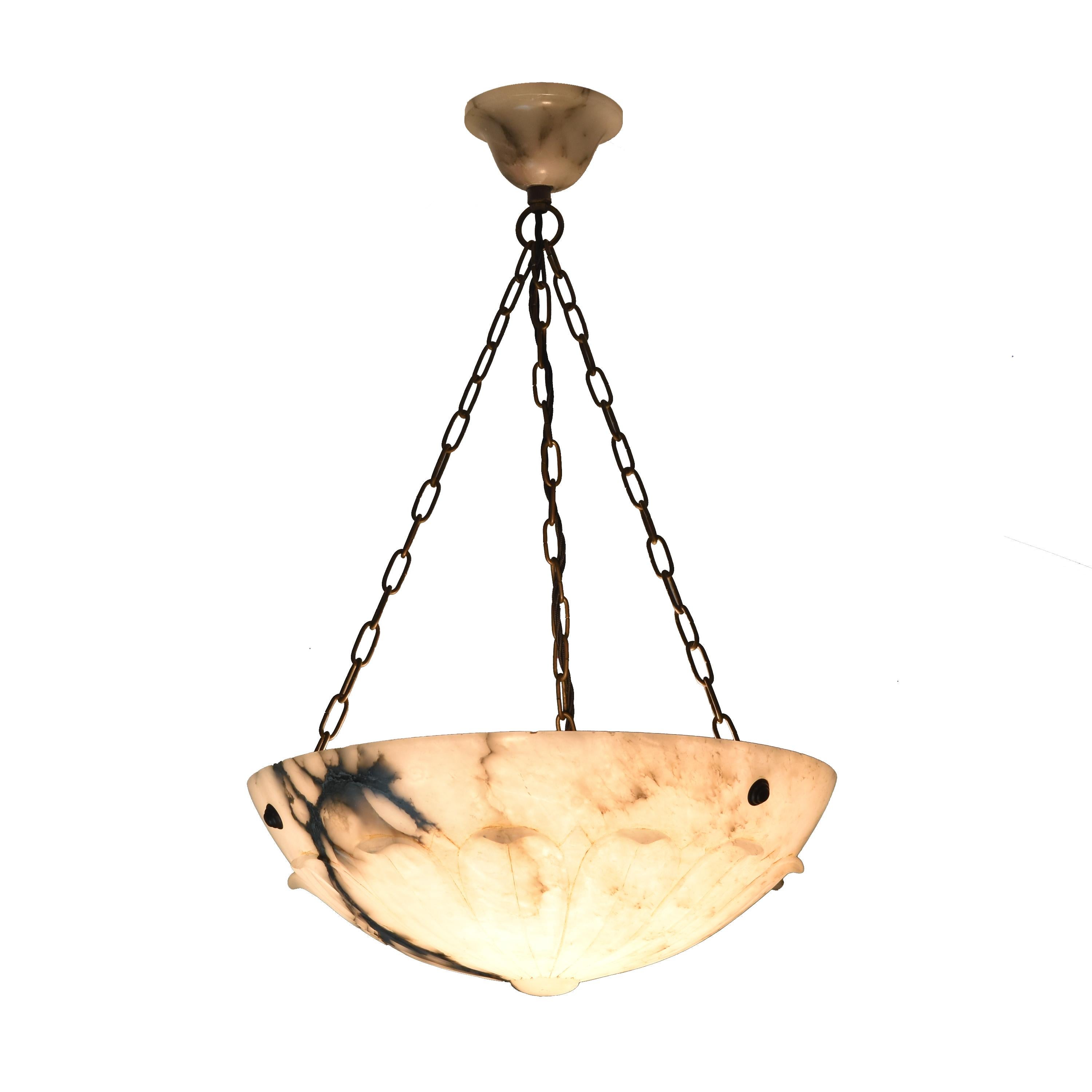 An elegant French Art Deco Alabaster ceiling lamp featuring a carved blossom-like decoration and its alabaster canopy.
This lamp is fitted with an E27 socket and has been newly rewired for the European market.
The finely marbled stone emits a warm