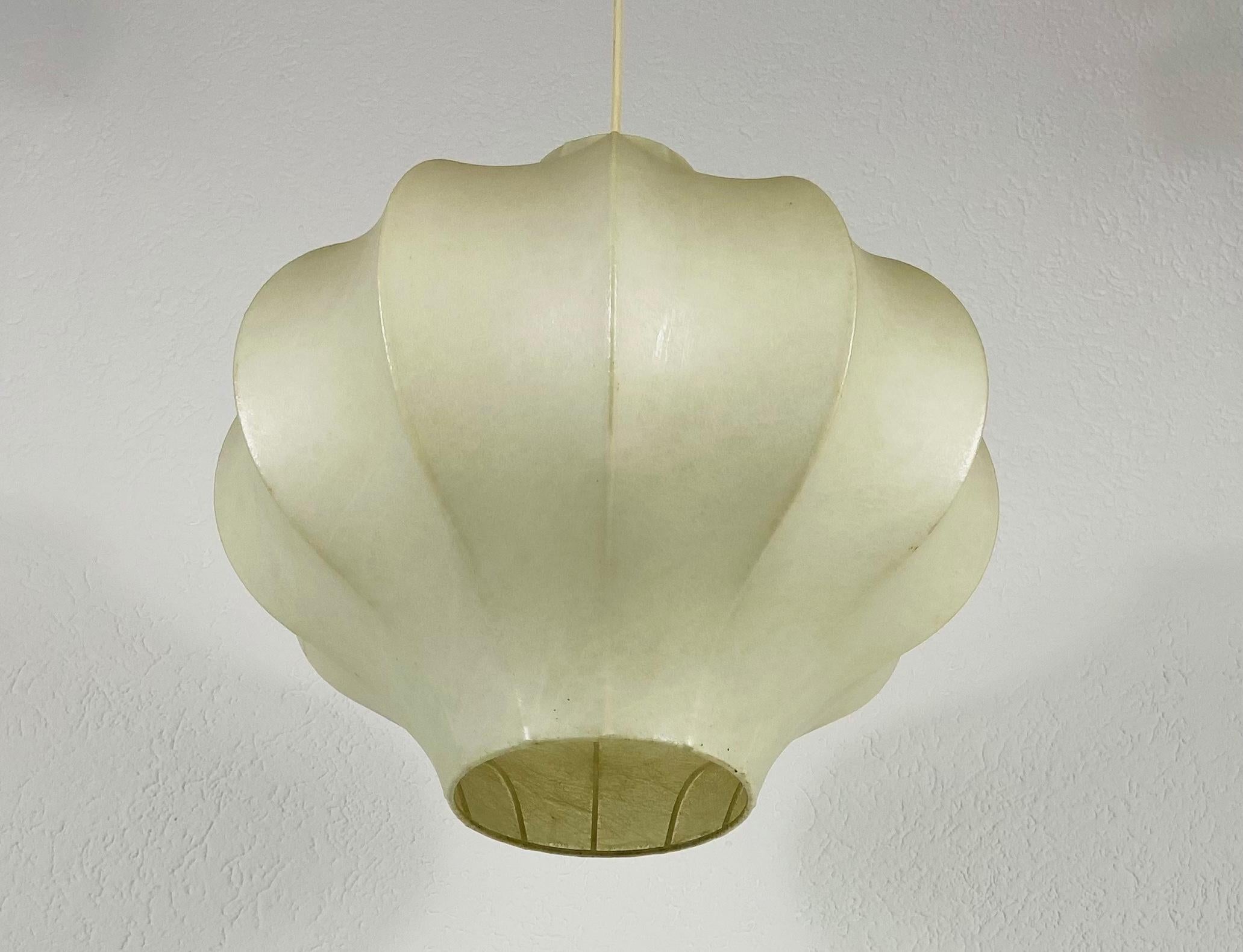 A cocoon pendant lamp made in Italy in the 1960s. The hanging lamp has been manufactured in the design of the lamps made by Achille Castiglioni. The lamp shade is of original cocoon and has a flower shape. 

Measures: Max height 72 cm
Height 39