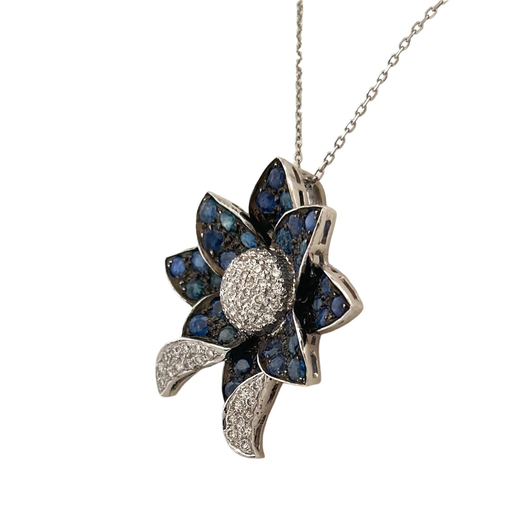 Exemplifying the timeless beauty of the early 20th century, this Flower-Shaped Pendant, adorned with White Diamonds and a Blue Sapphires, is truly a work of art. Weighing a total of 8.2 grams, it boasts an intricate and delicate design. The flower's