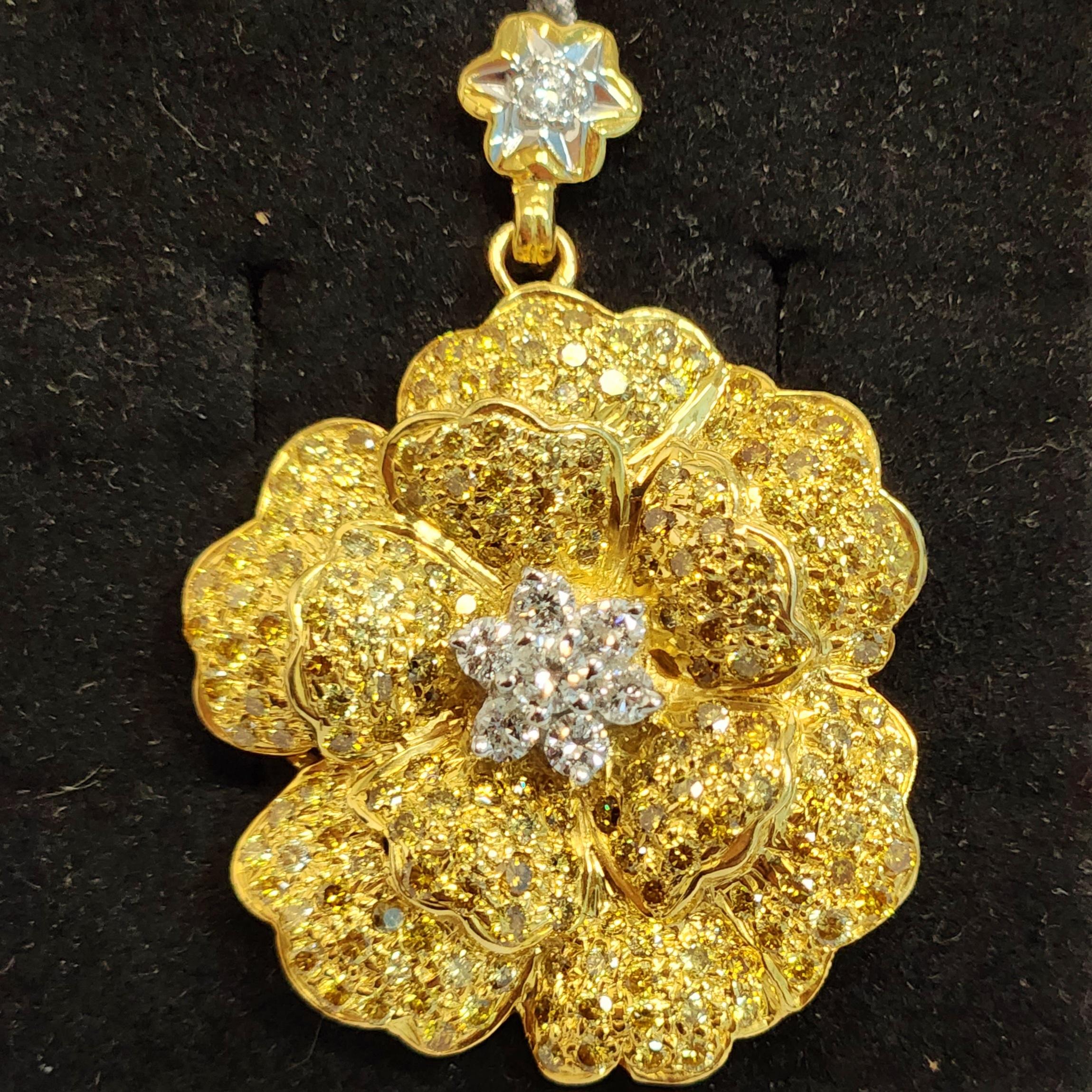This Flower Shaped Fancy Diamond Pendant is a stunning piece of jewelry that features a beautiful floral design. The center of the flower is crafted with white round diamonds, adding a bright sparkle to the piece. The petals are crafted with shining