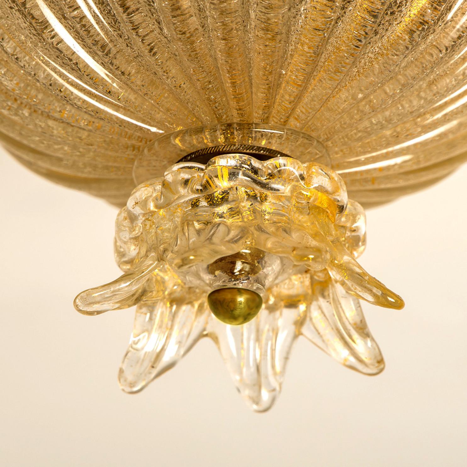 An elegant blown Murano glass flush mount by Barovier & Toso. The light fixture is made of thick Murano glass with gold details. Mounted on a white back plate. The lights refract light beautifully. The flush mount fills the room with a soft, warm