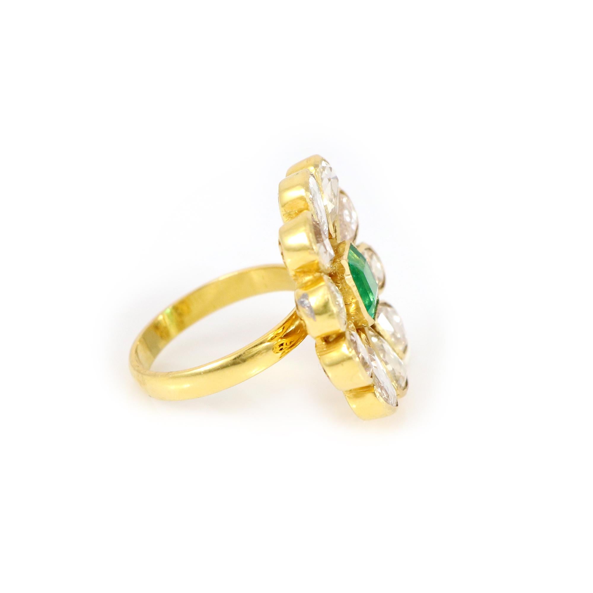 Explore our exquisite 18K yellow gold flower-shaped ring, adorned with a radiant emerald symbolizing love and harmony. Delicate hand-selected rose-cut diamonds encircle the Zambian emerald, adding brilliance and elegance. This timeless piece is more