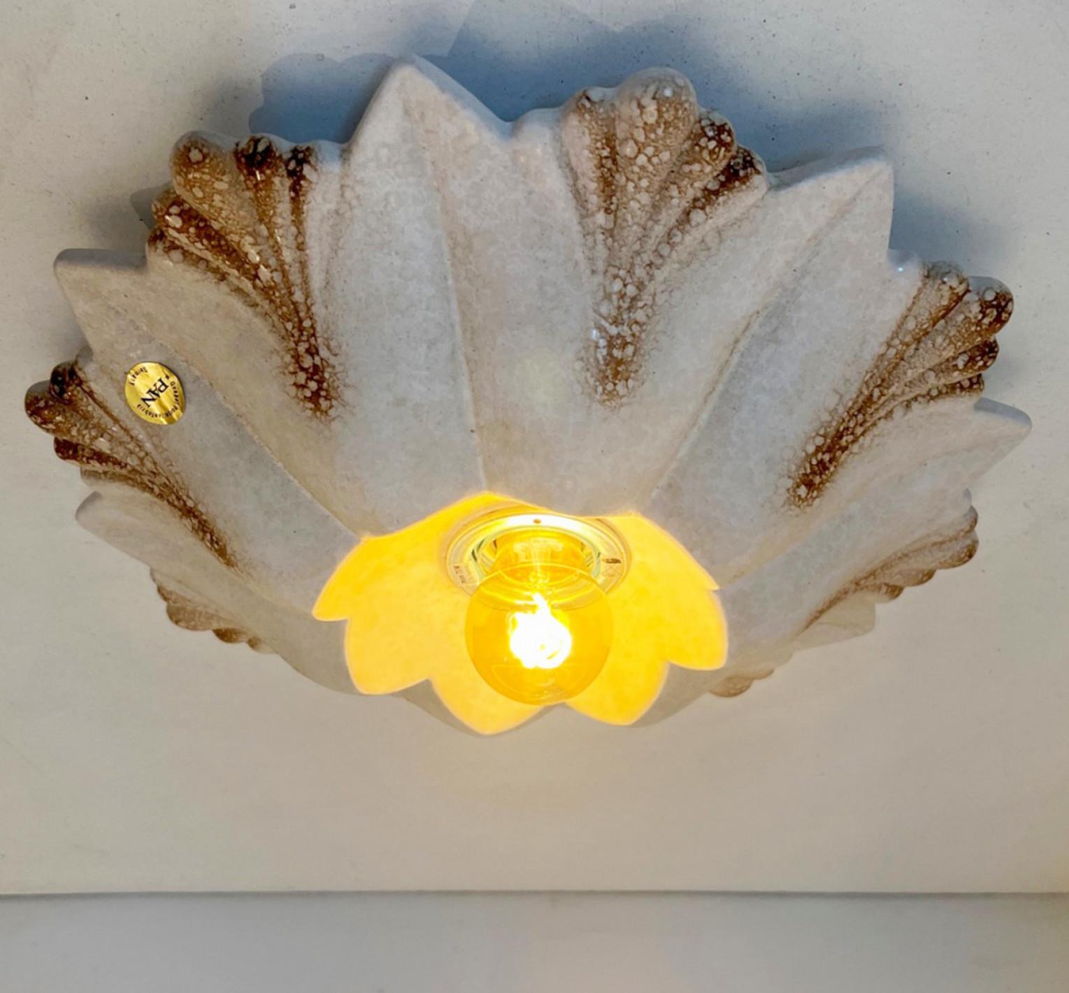 Blumenförmige Wandleuchte aus Keramik in weißem Sand im Stil von Fat Lava. Hergestellt von Hustadt Leuchten Keramik, Deutschland, in den 1970er Jahren.

Die Art der Glasur wird 