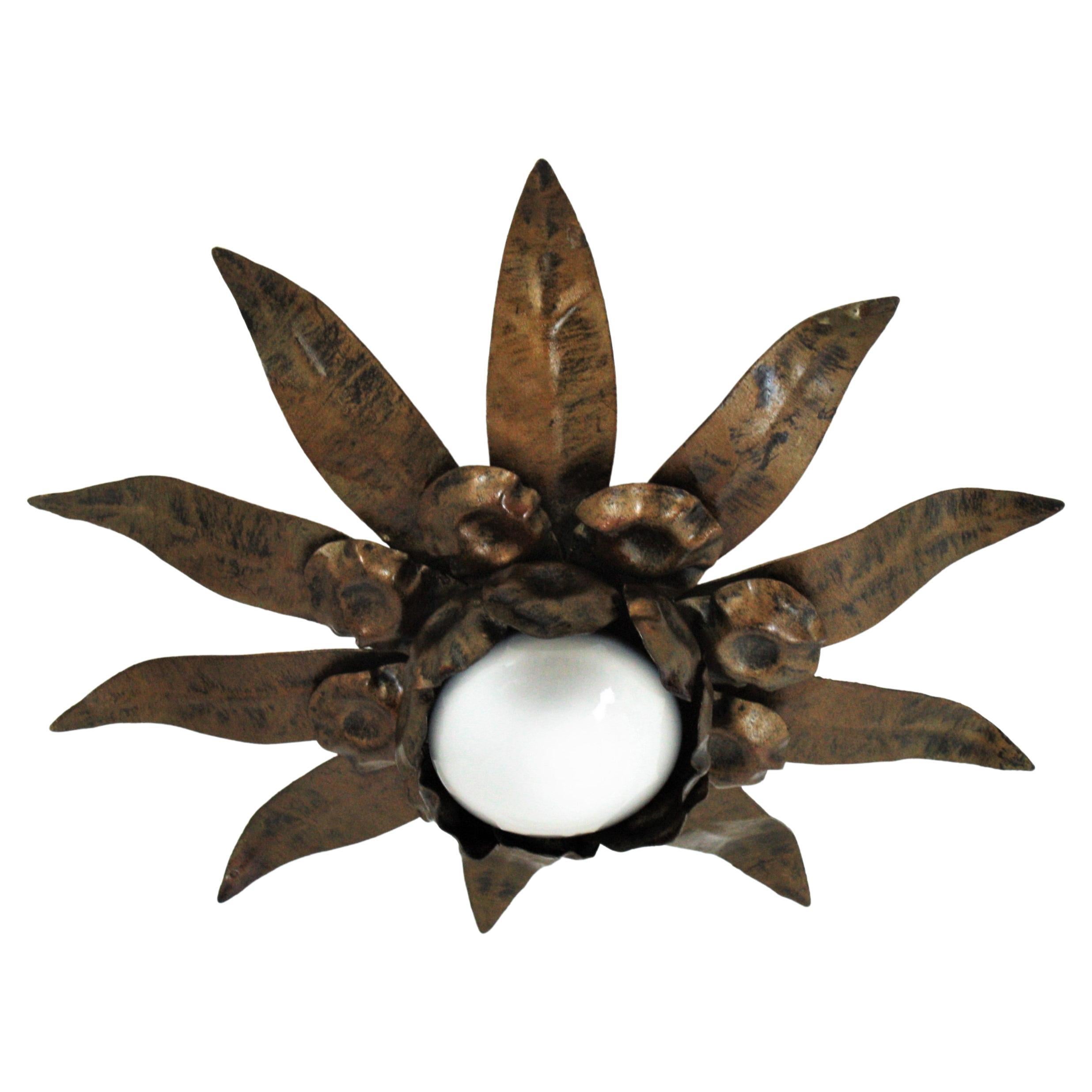 Flower Sunburst Flush Mount, Gilt Iron. Spain, 1960s.
This ceiling light features a flower shaped frame with three layers of leaves in different sizes surrounding a central exposed bulb. Patinated in bronze gilt color.
This sunburst light fixture