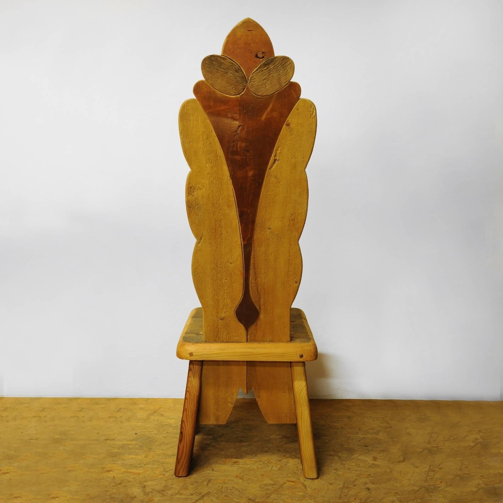 Part of a stunning collection of Throne chairs, this piece is crafted using old wood reclaimed from 16th century floors. The stunning silhouette is made of a sturdy and low base with an elongated backrest in the elegant shape of a budding flower.