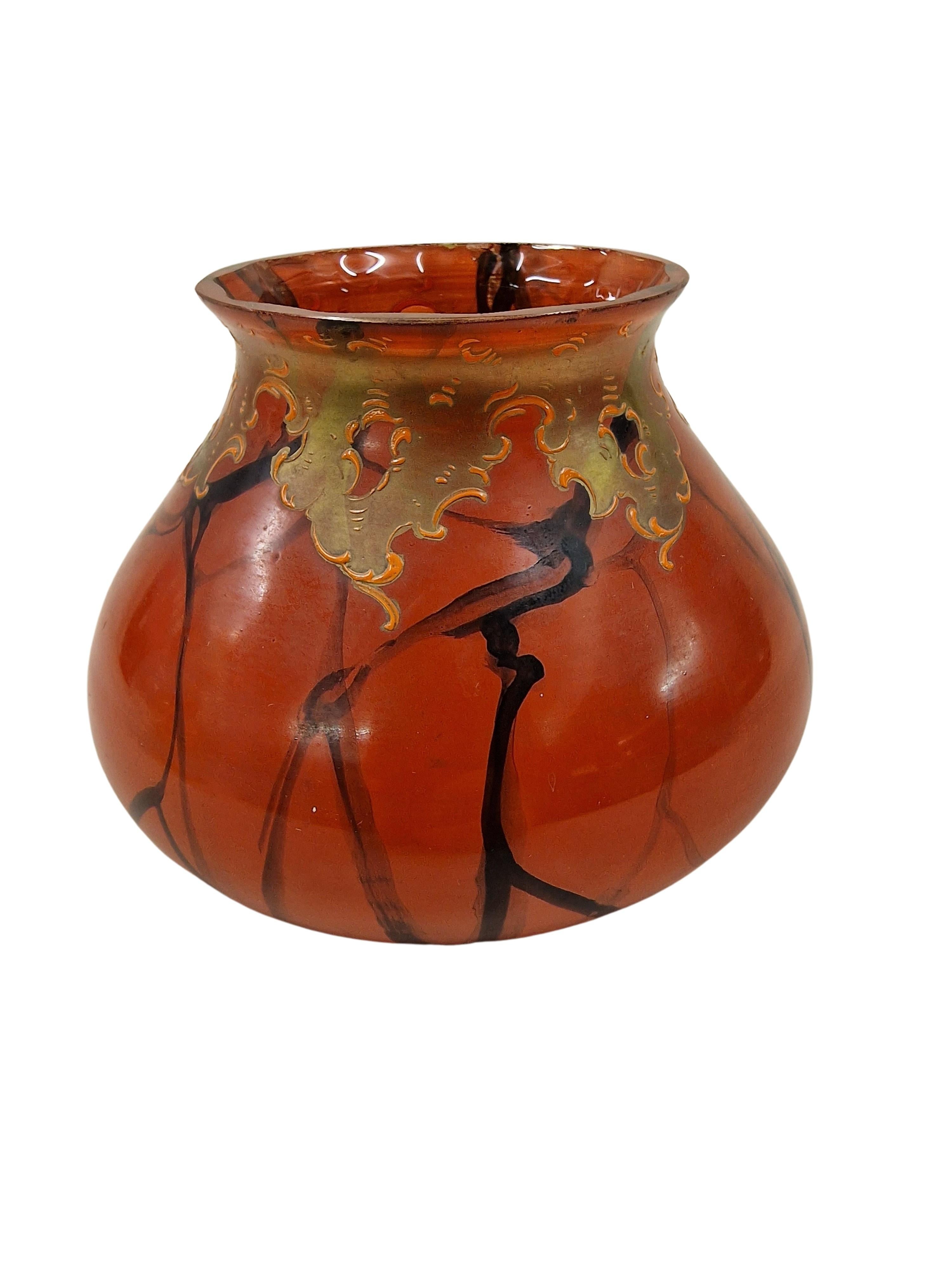 Ce vase français est un très bel objet de l'époque Art Nouveau / Jugendstil. 
Le corps du verre est en verre orange avec un sommet magnifiquement taillé. L'ensemble du corps bolbique est peint à l'infini avec un décor de branches stylisées, ce qui