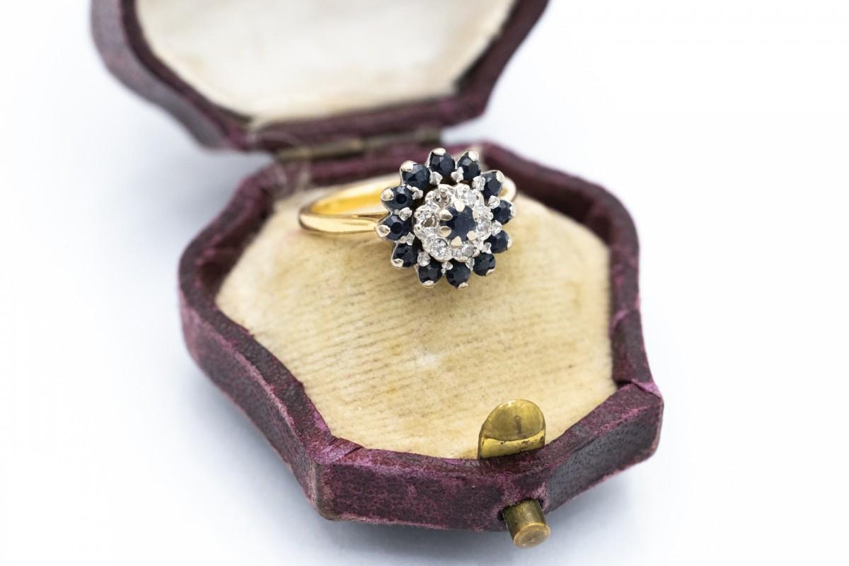 Anello in oro 18 carati (finezza 750). Con 13 zaffiri naturali blu rotondi del peso di circa 0,60 carati. Inoltre, 6 diamanti con taglio 8/8 del peso di circa 0,10ct (purezza VS-SI e colore F-H).

Peso del prodotto: 3,7 g.

Dimensioni: 10 (50) - è