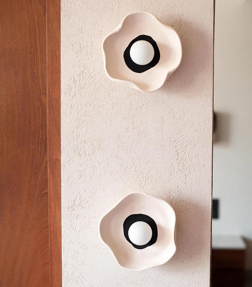 Lampada da parete a fiori di Harshita Jhamtani Designs
Dimensioni: D 5 x L 20,3 x H 20,3 cm
Materiali: Argilla.

Ti presentiamo la nostra incantevole applique, ispirata alla delicata bellezza dei fiori organici. Il suo design accattivante è