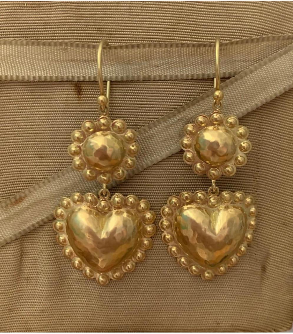 Flower with hearts earrings are designed by Christina Alexiou. 
This pair of drop earrings is crafted with 18k gold and are made in Greece. The hearts and flowers are hollow, thus makes this pair of earrings an easy-to-wear everyday piece of