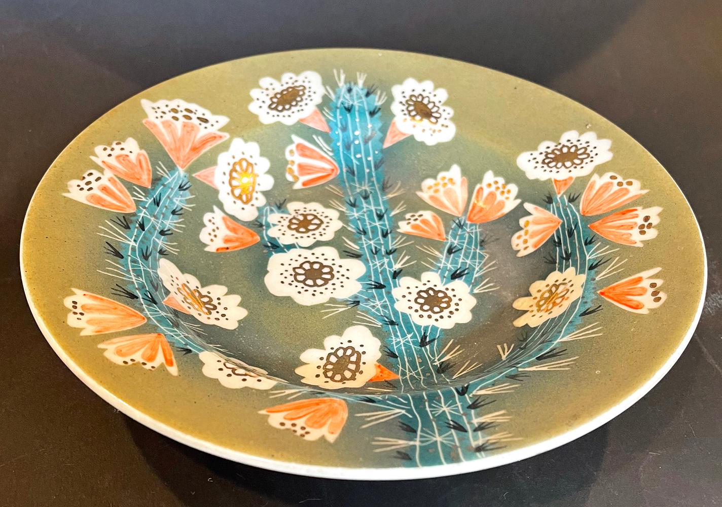 Beautifully glazed in tones of mossy green, papaya, ivory and blue topaz, this bowl by Waylande Gregory depicts a cactus laden with brilliant blossoms. Gregory was one of America's greatest sculptors and ceramicists before and after World War II. He
