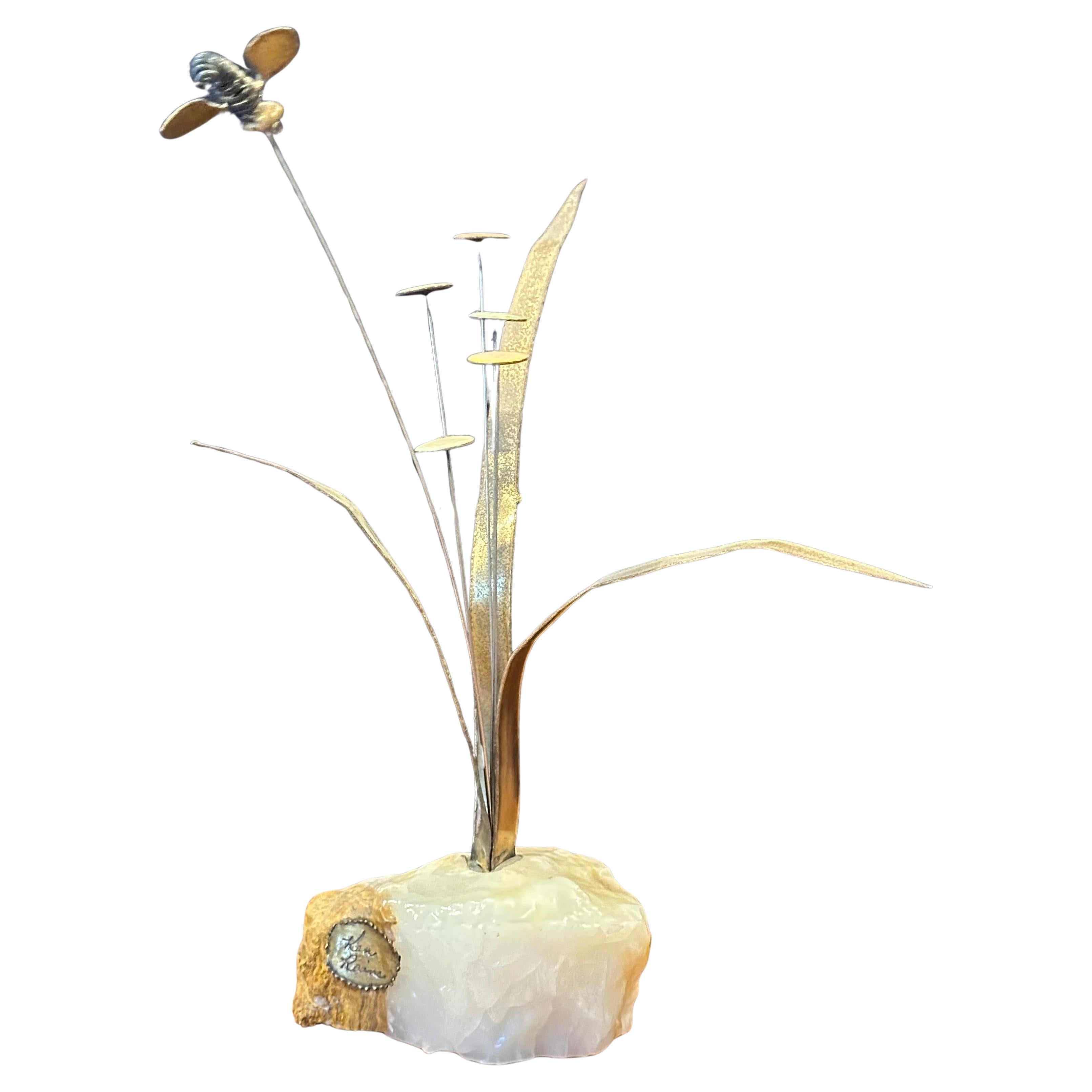 Whimsical flowers with bee sculpture in mixed metal on quartz base by Ken Rains, circa 1970s.  The sculpture is in very good vintage condition and measures 8.5