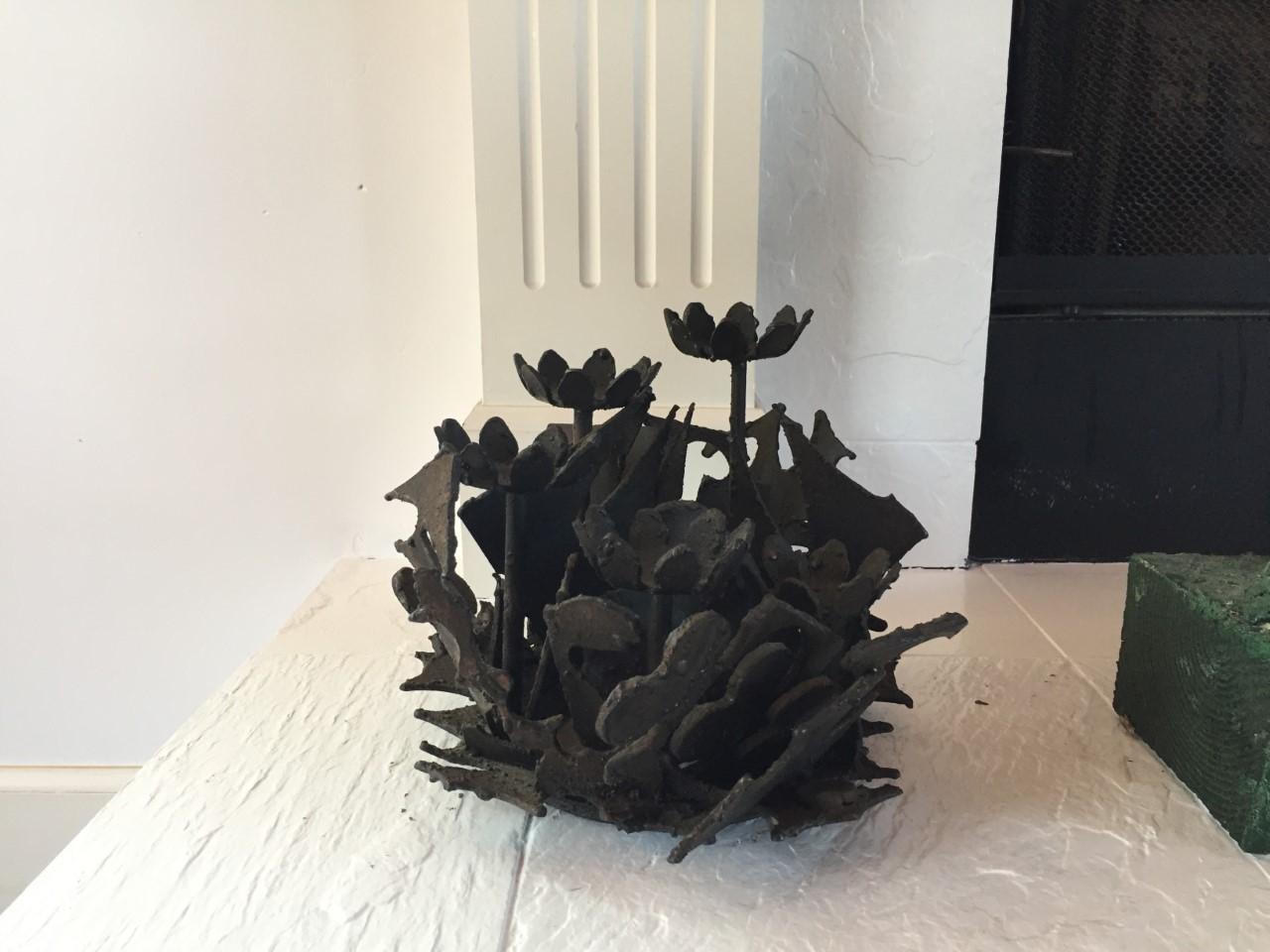 Brutalist welded-steel sculpture by Harry Wasserman. At 8.25” tall and 10” wide, this sculpture has an incredible elegant presence. Encircled flowers and leaves captured in steel evoke abstract and linear shapes. The somber and rough techniques of