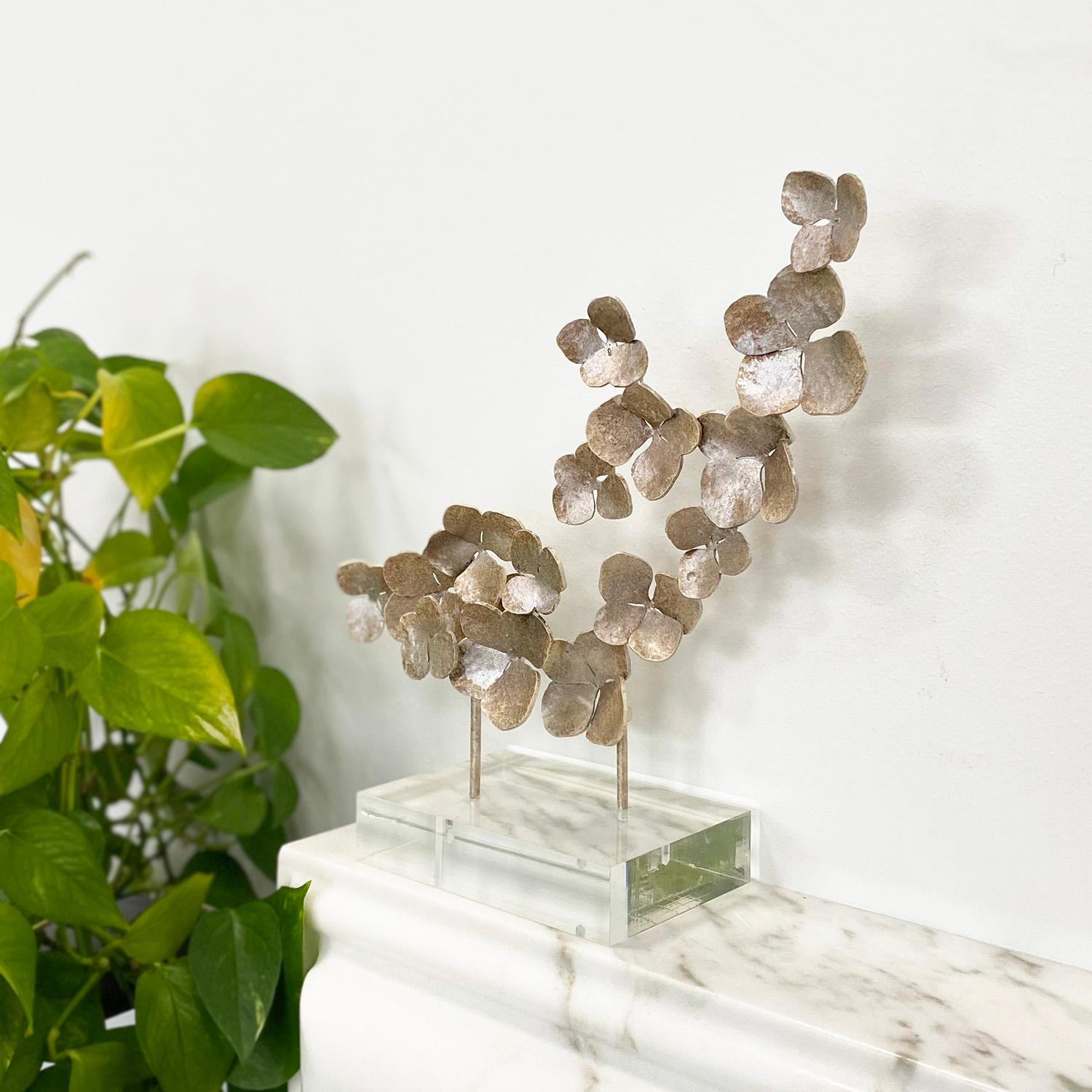 Aggiungi un tocco di lussuoso estro al tuo spazio con questo squisito accessorio. Con fiori fatti a mano, piegati singolarmente e montati su una base in acrilico, questo oggetto sarebbe l'aggiunta perfetta a qualsiasi tavolo, scrivania o libreria.