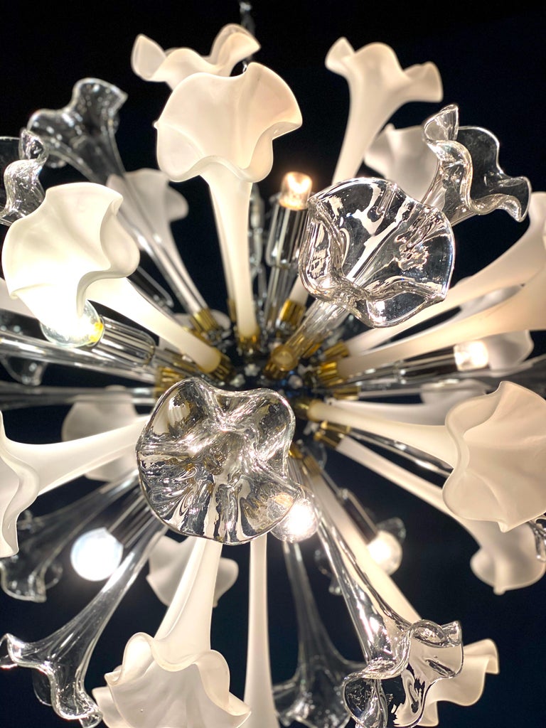 Large contemporary Sputnik chandelier composed of precious hand blown Murano flowers art glasses with clear and white color. 
 Available also a pair.
Chromed steel spherical frame, with 10 E 14 \ 4 W light bulbs.
Measures: Diameter cm 70, height