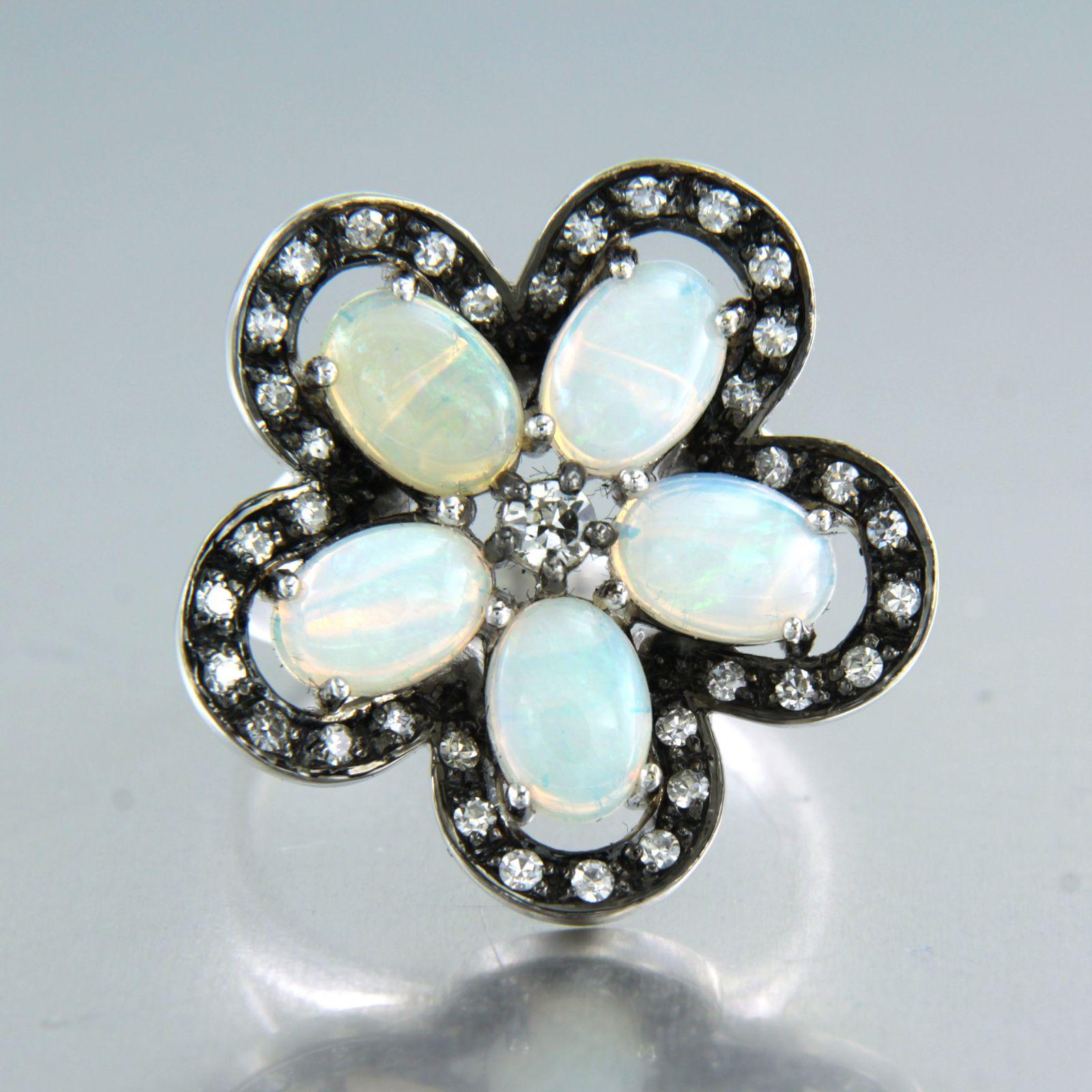 14k white gold ring in the shape of a flower set with opal and old mine cut and single cut diamonds - ring size U.S. 6.75 - EU. 17.25(54)

detailed description:

the top of the ring is rhodium plated and has a diameter of 2.3 cm wide

Ring size U.S.