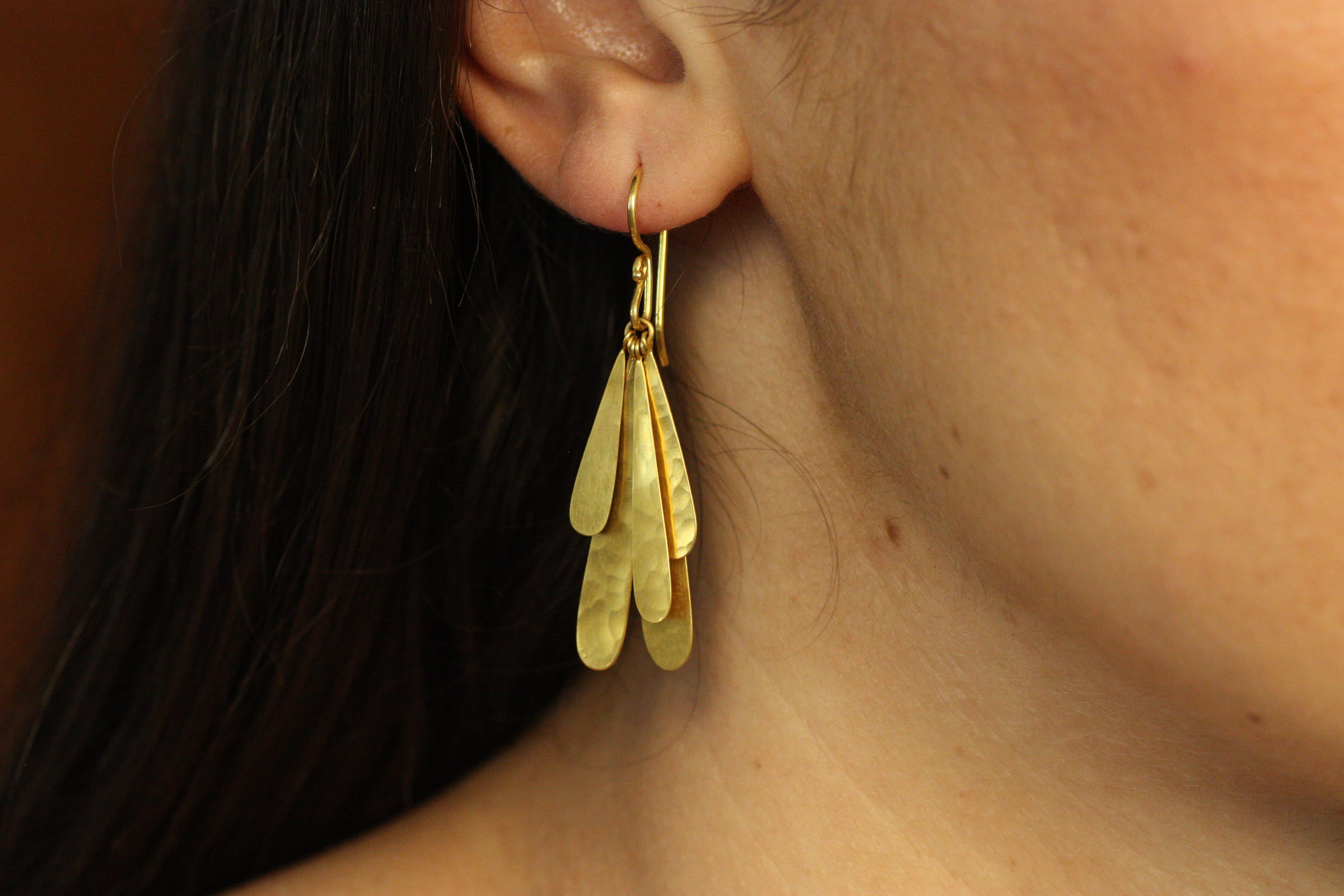 Questi orecchini con petali a cascata, realizzati a mano, sono una lussuosa dimostrazione di eleganza e movimento. Realizzati in oro giallo 22 carati con finitura martellata, gli orecchini presentano forme stratificate simili a petali che brillano a