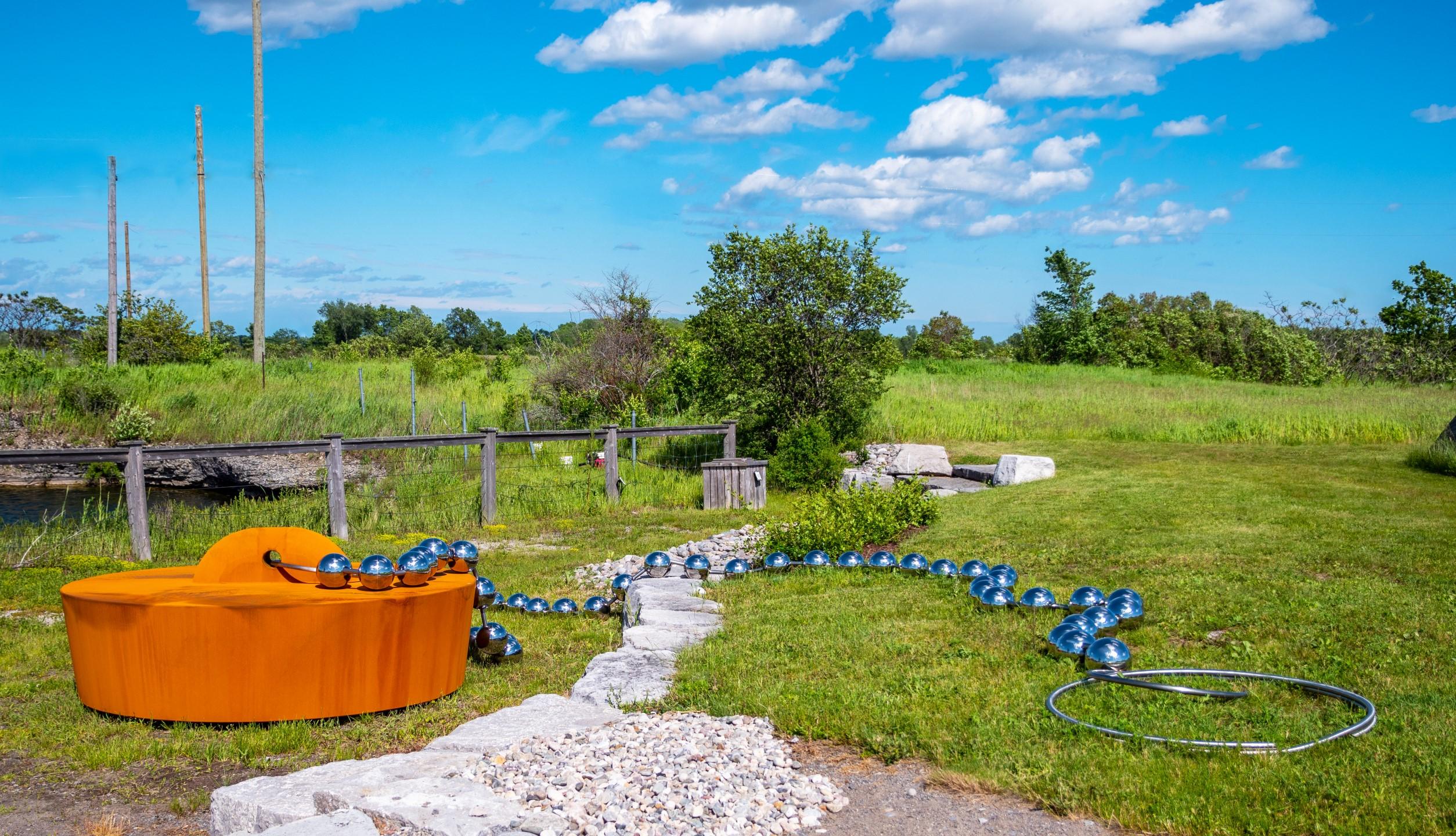 We have just installed Floyd Elzinga's playful and Pop art inspired outdoor sculpture Drain the Swamp next to the water feature on our property. The super sized corten steel replica of a rubber bath stopper is attached to a polished stainless steel