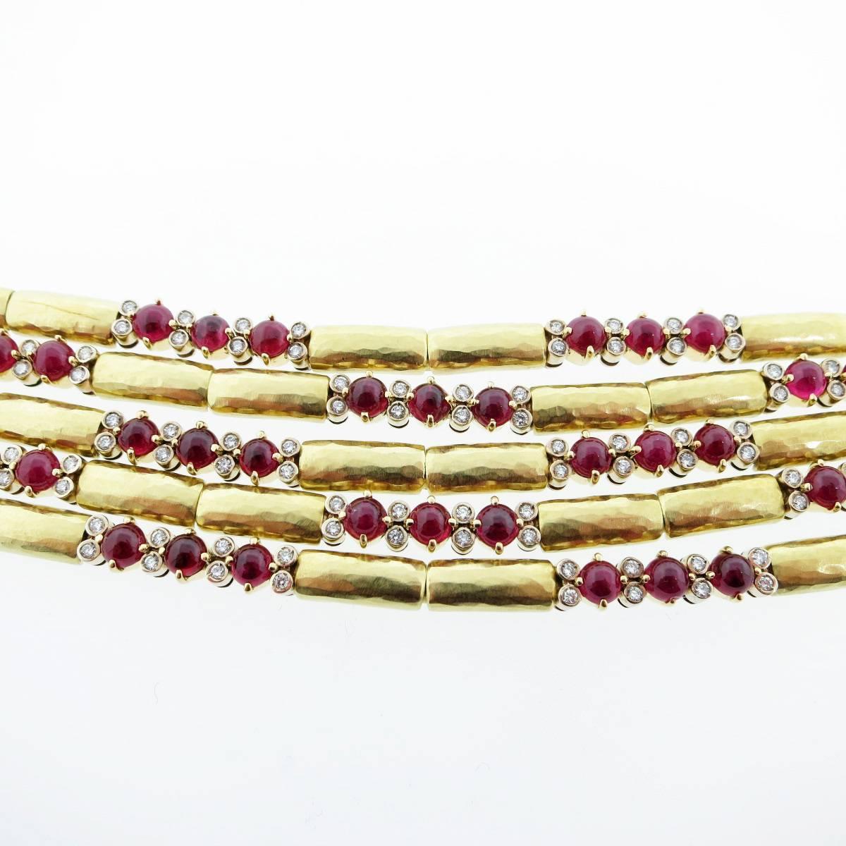 18kt. yellow gold five fluid strand bracelet. Each strand is strung with matte finish barrel shape links that flow independently on the wrist spaced with 36 prong set round cabochon fine natural rubies totaling approx 18cts. and 96 bezel set round
