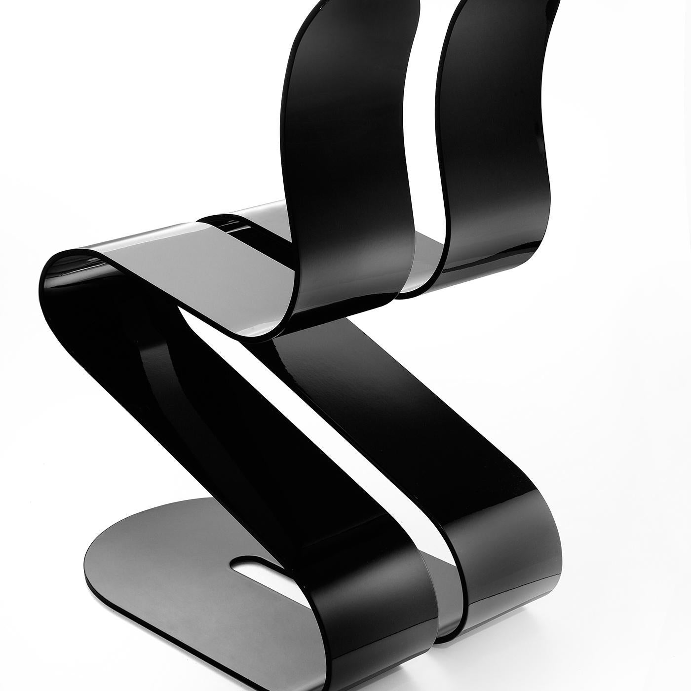 Handcrafted of a single piece of aluminum artfully bent to resemble a ribbon, this chair's design is inspired by the natural curves of the body. The ergonomic silhouette provides support to the back while the cut in the center gives flexibility to