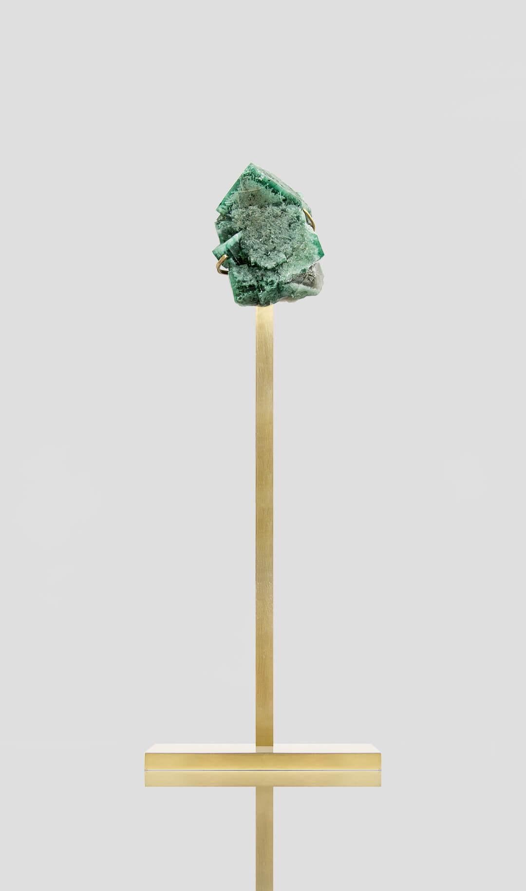 Cristallo di fluorite britannico isometrico elegantemente esposto tra grappoli di cristalli di gemme - autenticamente incapsulato con un'estetica sorprendente che dettaglia la forma cubica isometrica contro l'elemento in ottone.

La fluorite è un