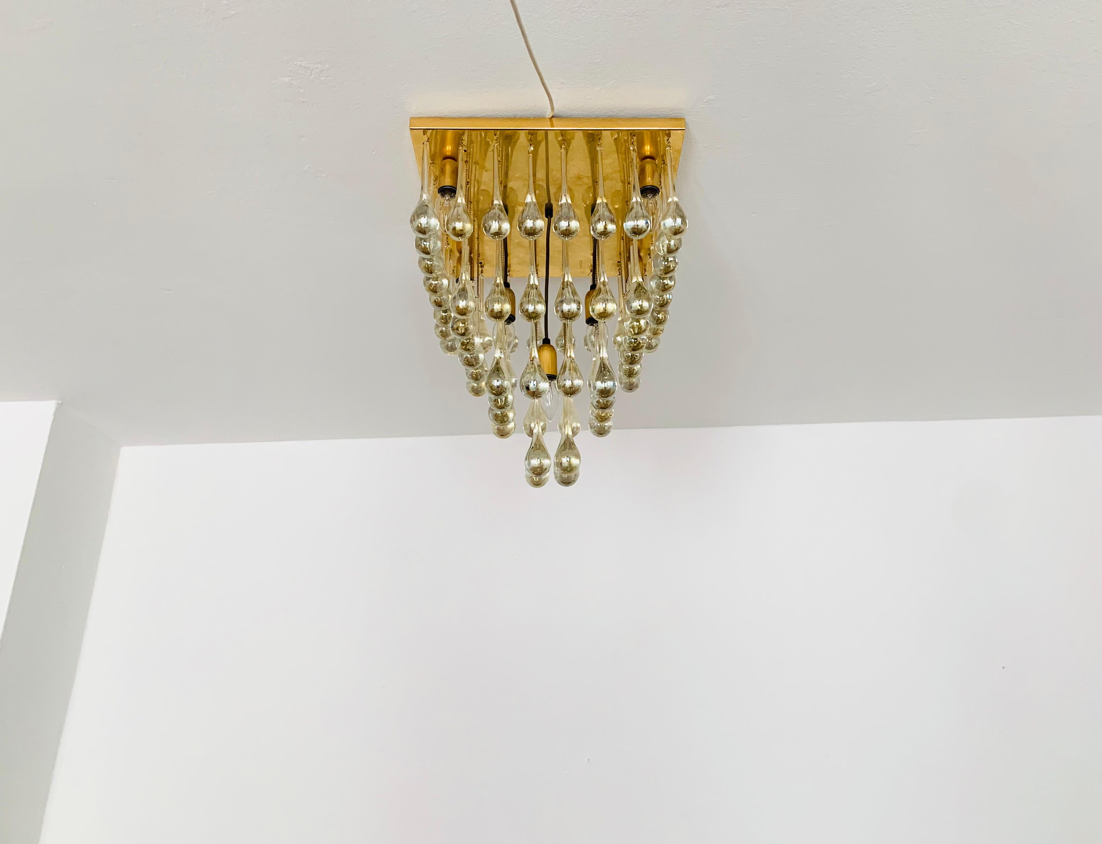 Imposing glass ceiling lamp from the 1960s.
Extraordinarily successful design and very high-quality workmanship.
The 64 glass drops spread a spectacular play of light in the room.
Very luxurious and an asset to any home.

Condition:

Very good