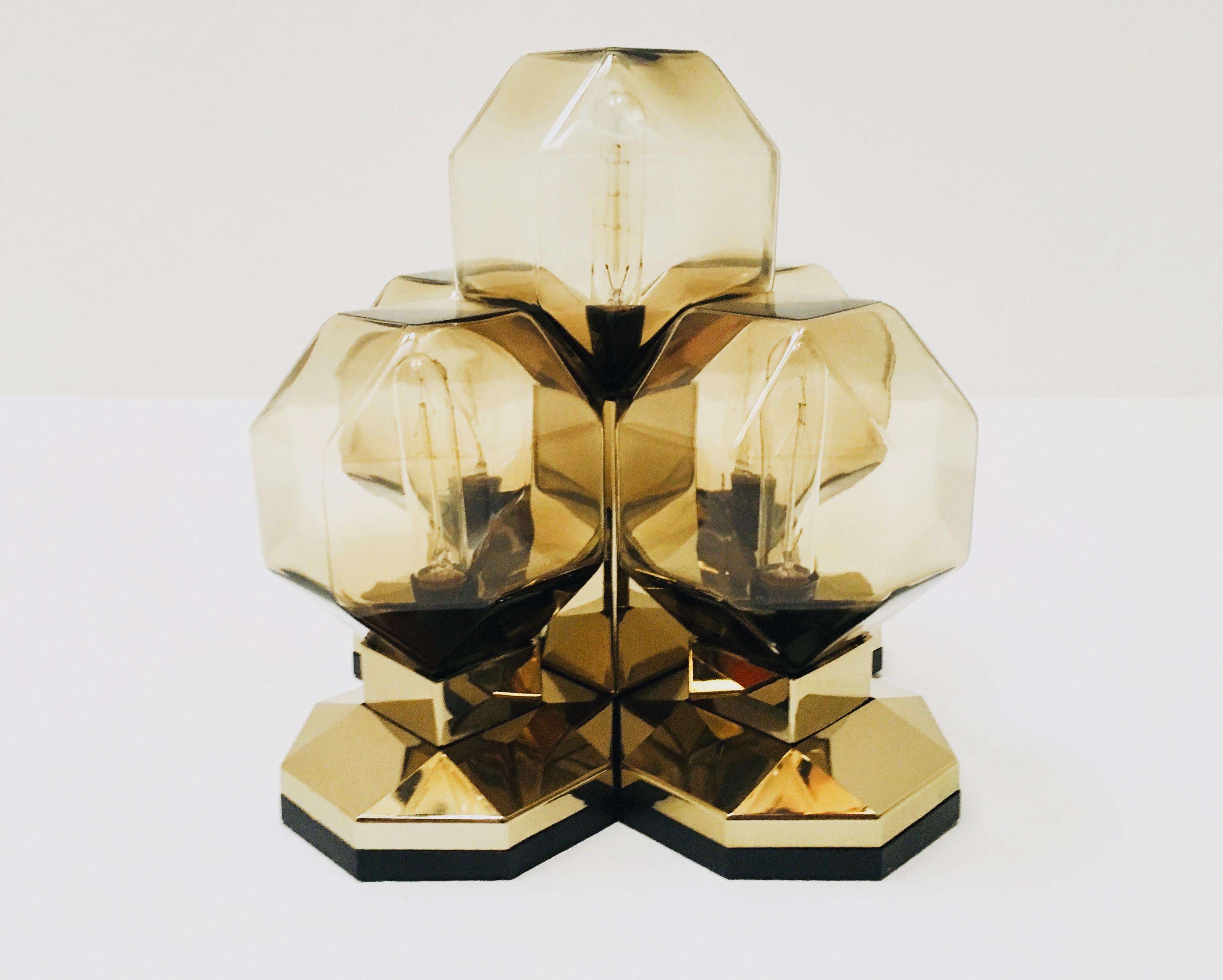 Extremely impressive module lamp from the 1970s.
Very unusual design and a real highlight for every room.
The lighting effect of the lamp is extremely beautiful and sparkling.
Very high quality processing.
This version in gold with the smoked