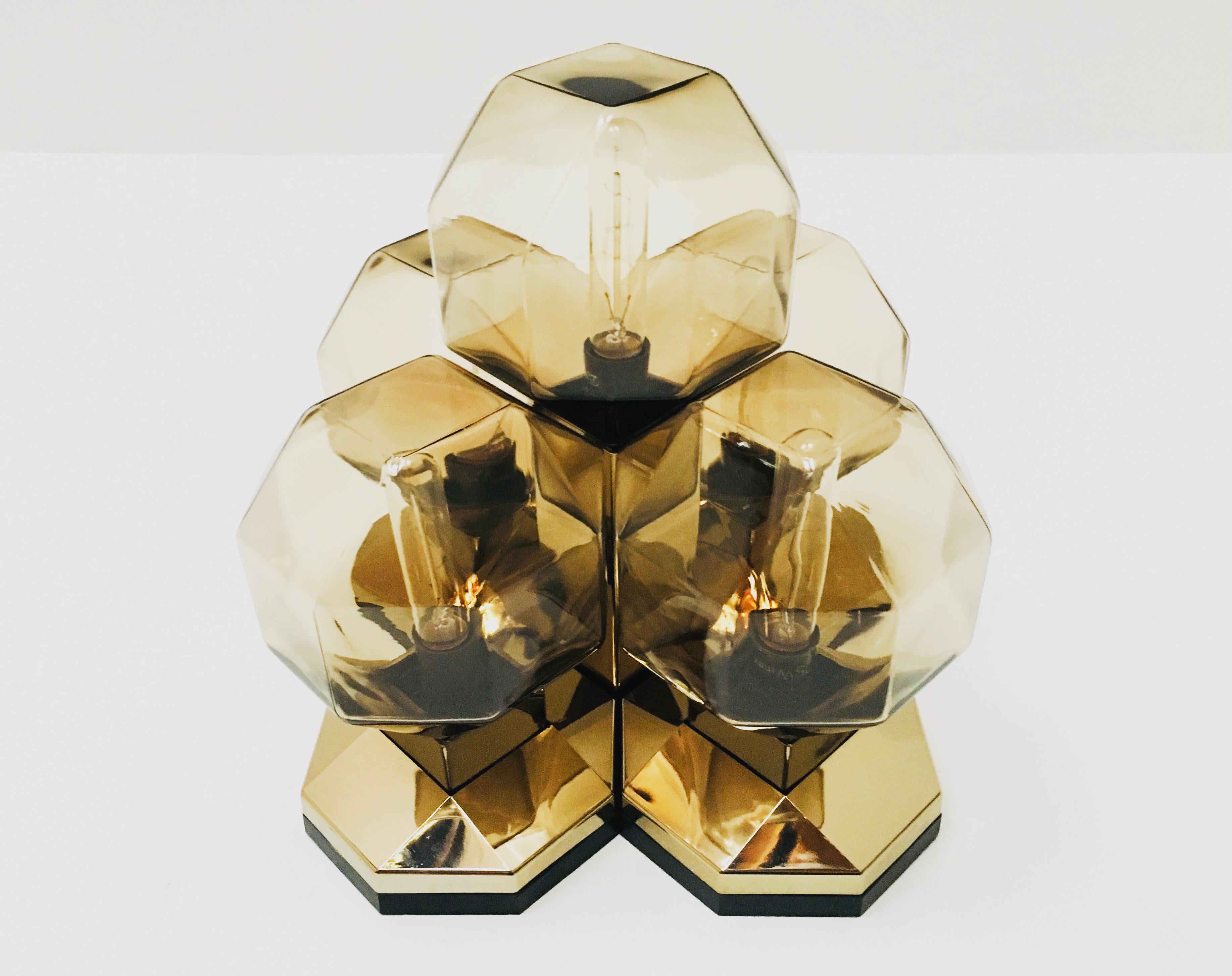 Extremely impressive module lamp from the 1970s.
Very unusual design and a real highlight for every room.
The lighting effect of the lamp is extremely beautiful and sparkling.
Very high quality processing.
This version in gold with the smoked glass