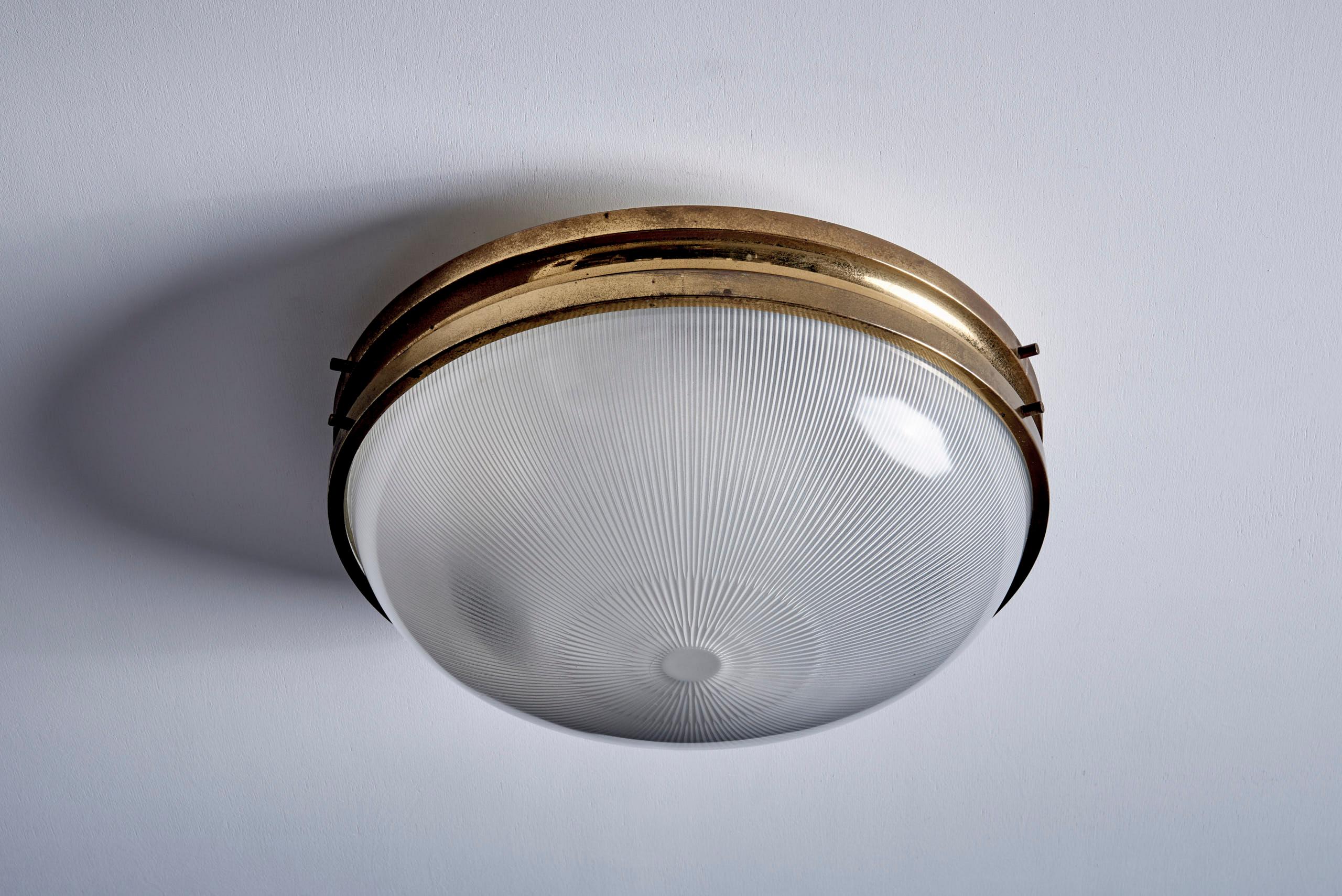 Lampe à encastrer en laiton et verre, Italie, années 1950. Cette pièce élégante présente un dôme en verre strié qui émet une lumière chaude et diffuse, dans un cadre en laiton massif à la belle patine vieillie. Convient aussi bien pour une