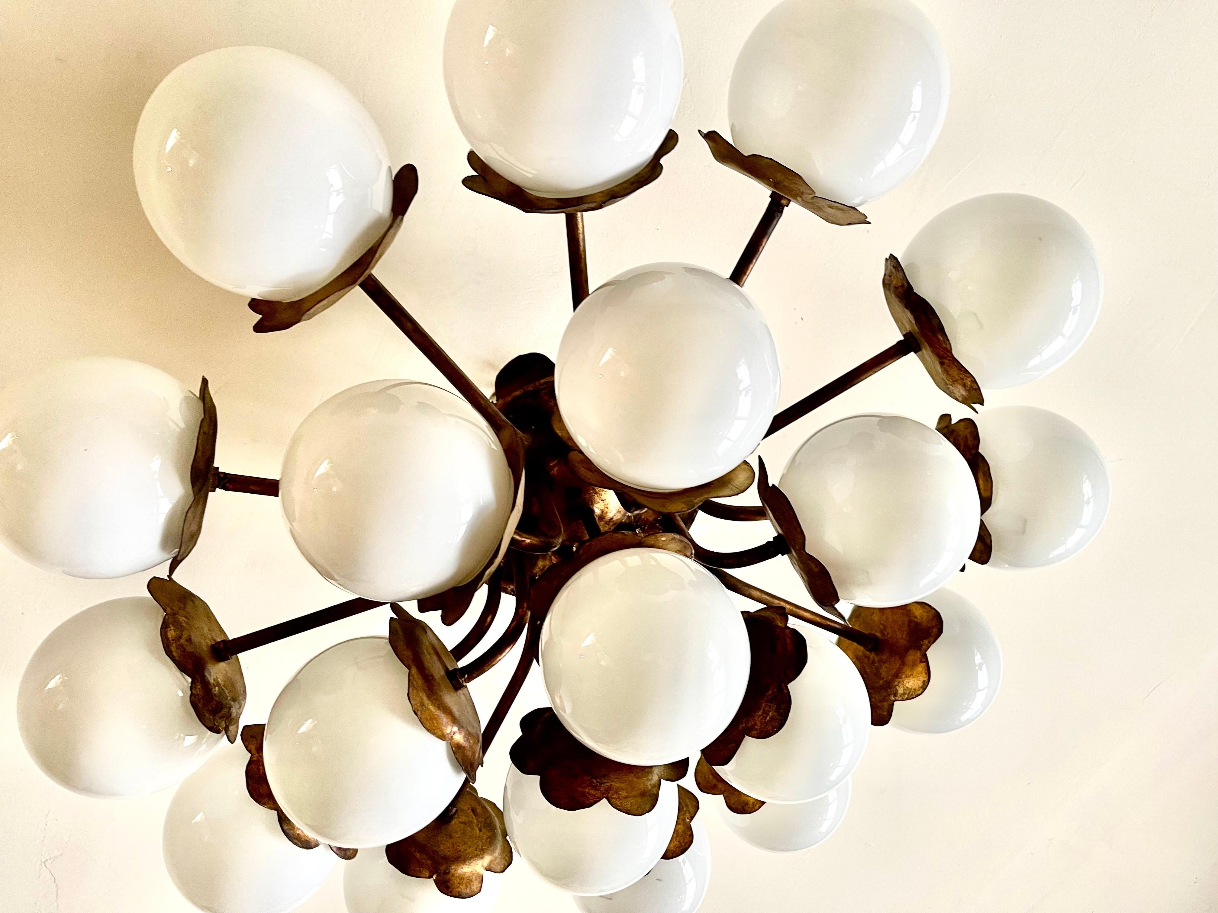 Lámpara de techo circular muy grande de metal martillado y dorado, compuesta por 19 globos de cristal opalino. Lámpara original de los años 50/60 de tendencia brutalista. una pieza decorativa que dará un ambiente único a tu interior

Precio de envío
