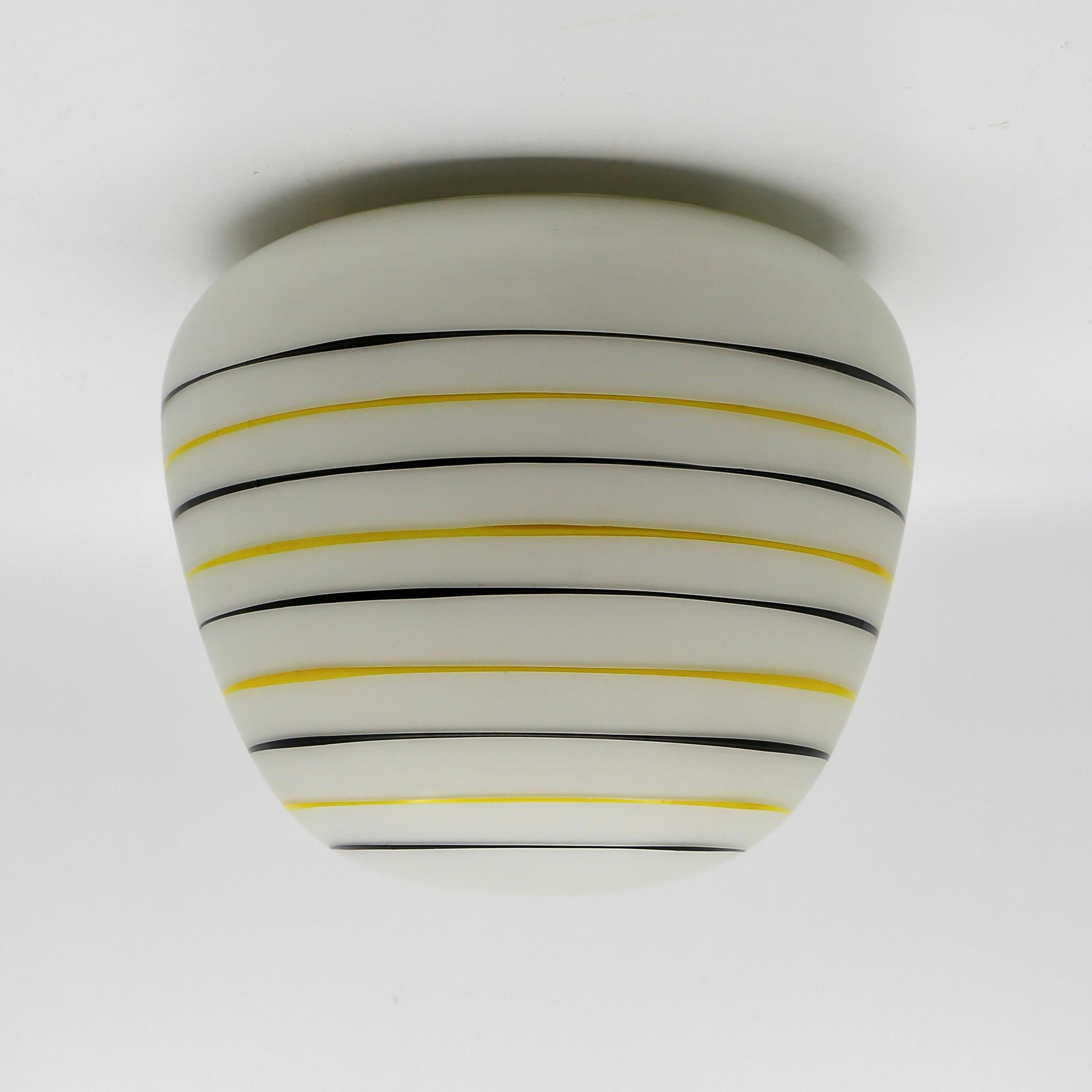 Beautiful glass vintage ceiling lamp from the 1950s/1960s by Philips Holland.

Production date: late 1950s
Produced by: Philips Holland
Material: glass and bakelite
Colors: decorative yellow and black lines on white glass.
Condition: the glass shade