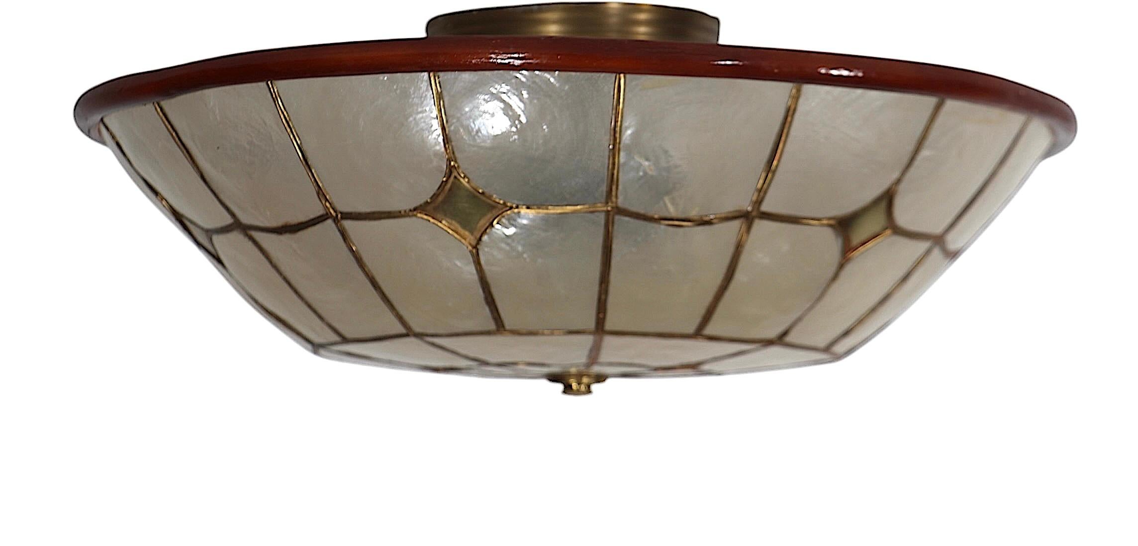 Rare capiz shell flush mount light fixture, having geometric repeating panels, set  in a brass frame.  We often find the capiz shell lamp shades, and occasionally  a capiz shell hanging chandelier, this is the first capiz shell flush mount fixture